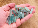 Green fluorite terminated carved point gemstone, 33mm, with natural crystal formations and smooth polished facets.