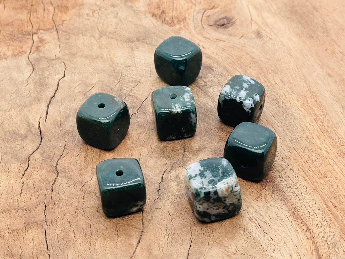 Handmade moss agate crystal incense holder with carved design, perfect for holding incense sticks in a decorative display.