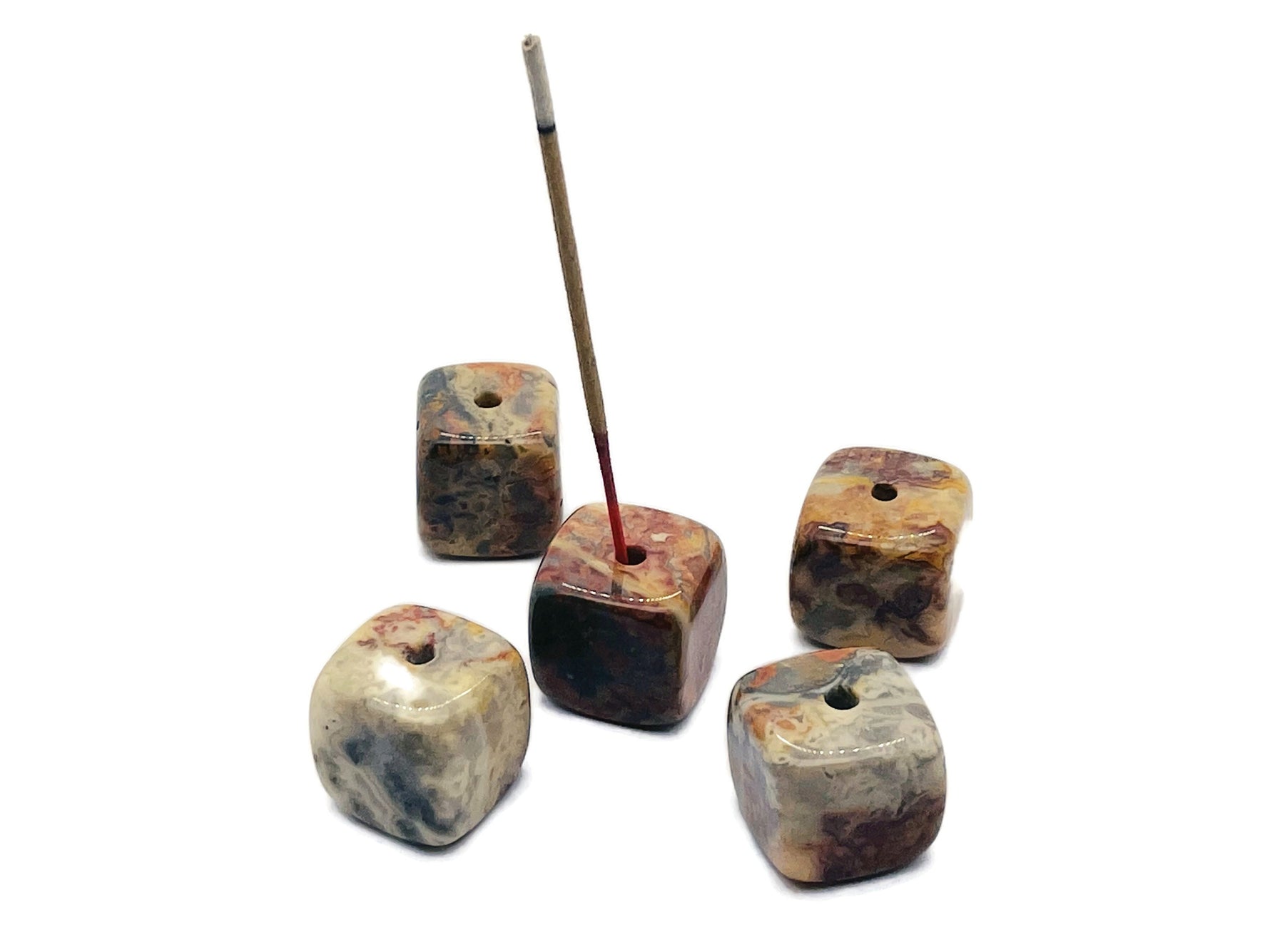 Handmade Crazy Lace Agate crystal incense holder with carved design, perfect for holding incense sticks in a decorative display.