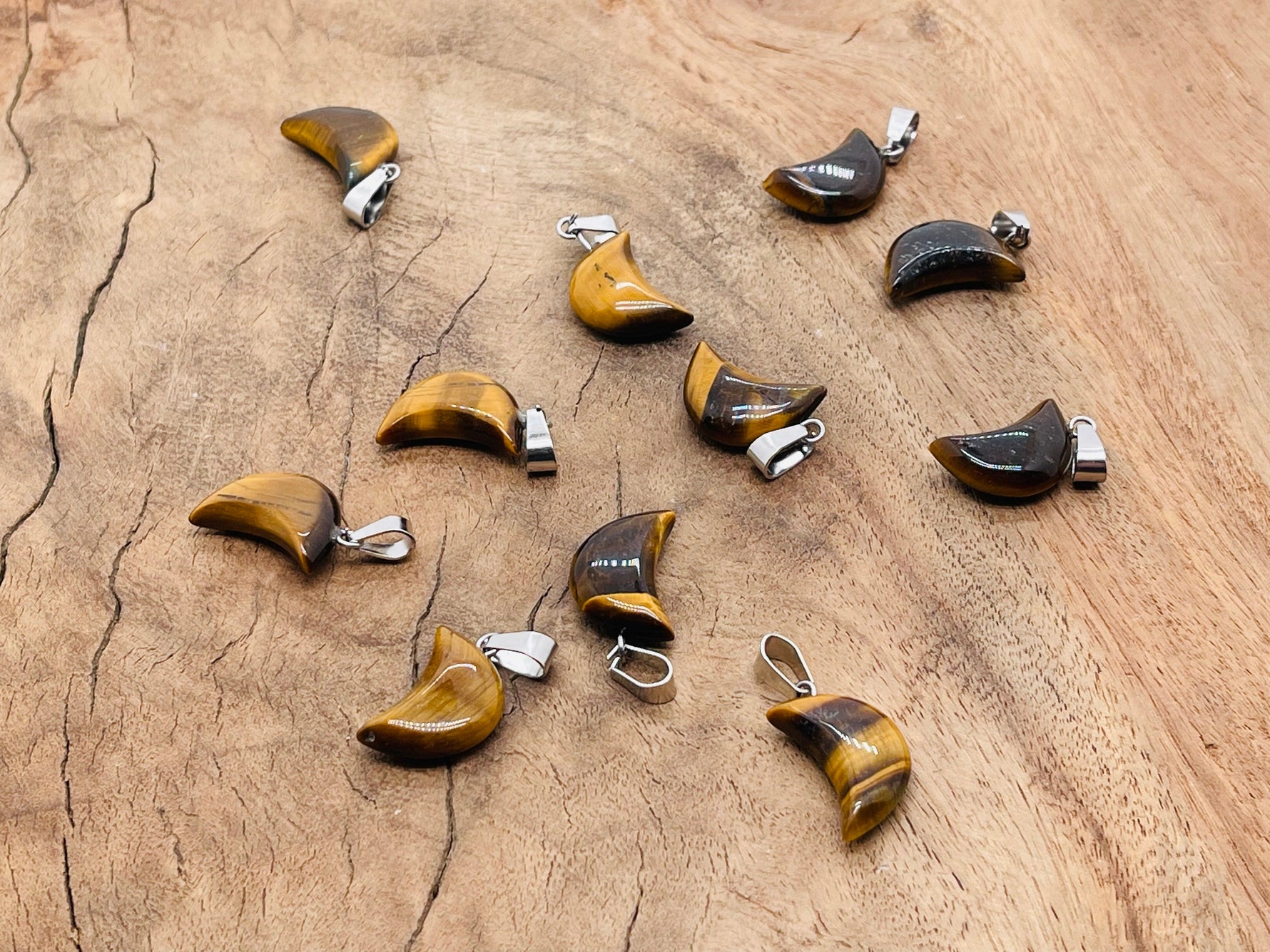 Tiger Eye moon-shaped crystal pendant from GemstoneGO, ideal for jewelry making, showcasing a polished, warm-toned gemstone design.