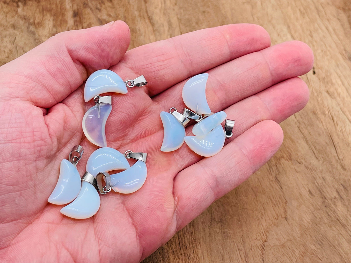 Opalite moon crystal pendant from GemstoneGO showing a smooth, glowing white gemstone with moon-like shape for jewelry making.