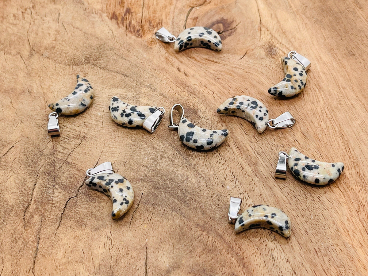 Dalmatian Jasper moon-shaped crystal pendant from GemstoneGO, ideal for jewelry making, featuring distinctive black spots on beige stone.