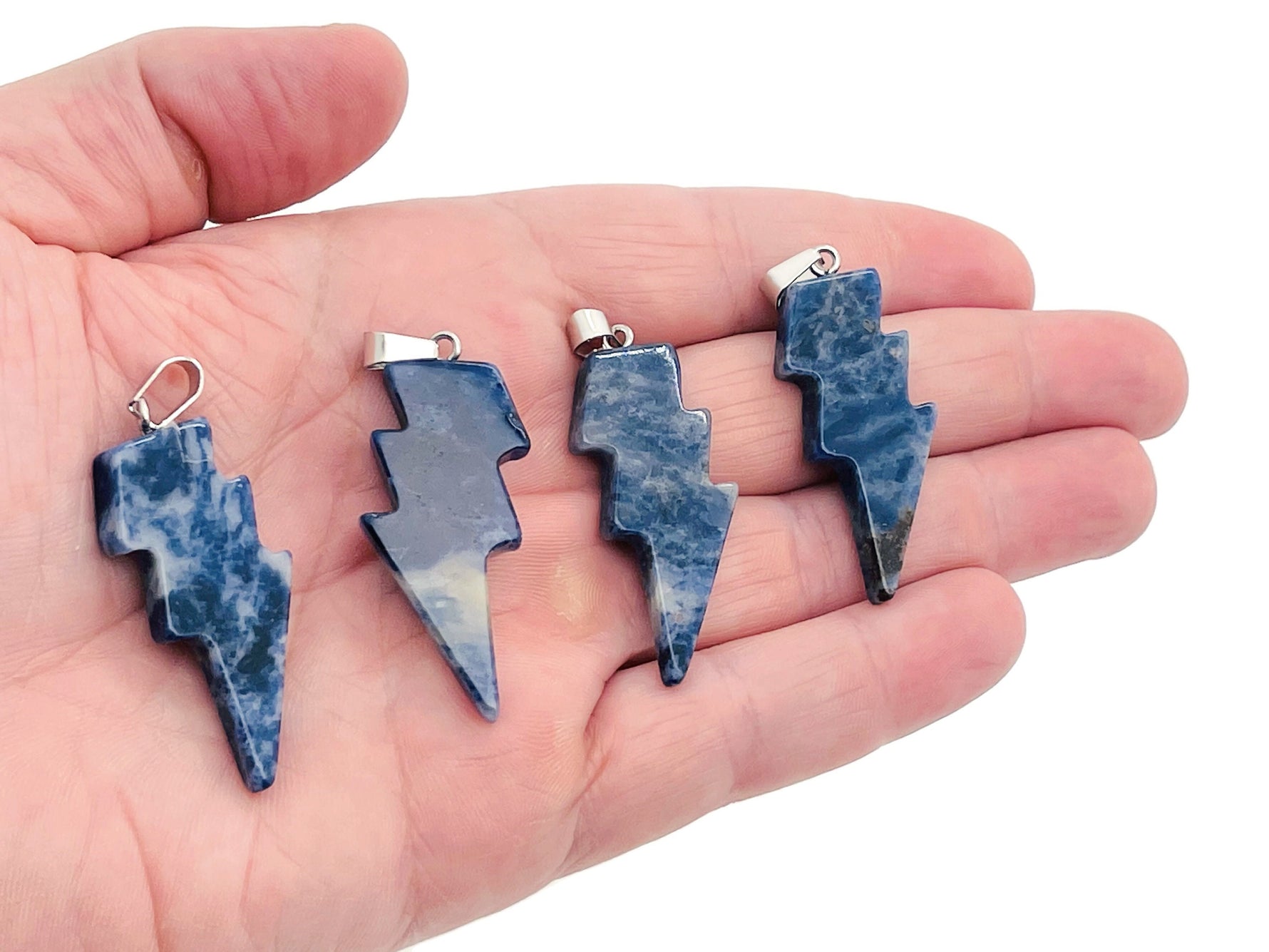 Sodalite Lightning Crystal Pendant from GemstoneGO featuring a striking lightning-shaped blue gemstone pendant on a silver chain.