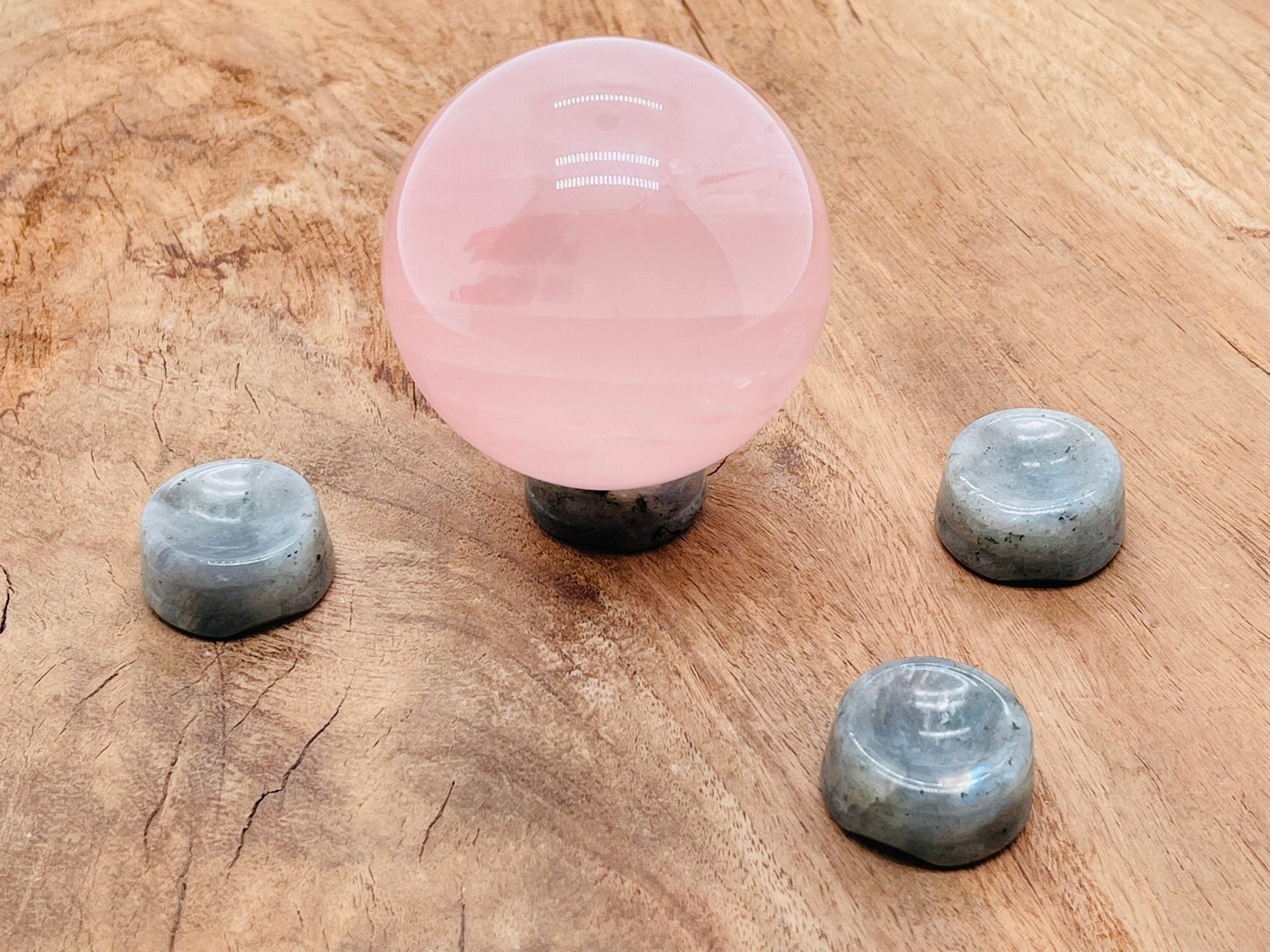 Labradorite crystal sphere with carved gemstone stand, decorative home decor piece showcasing iridescent blue and green hues.
