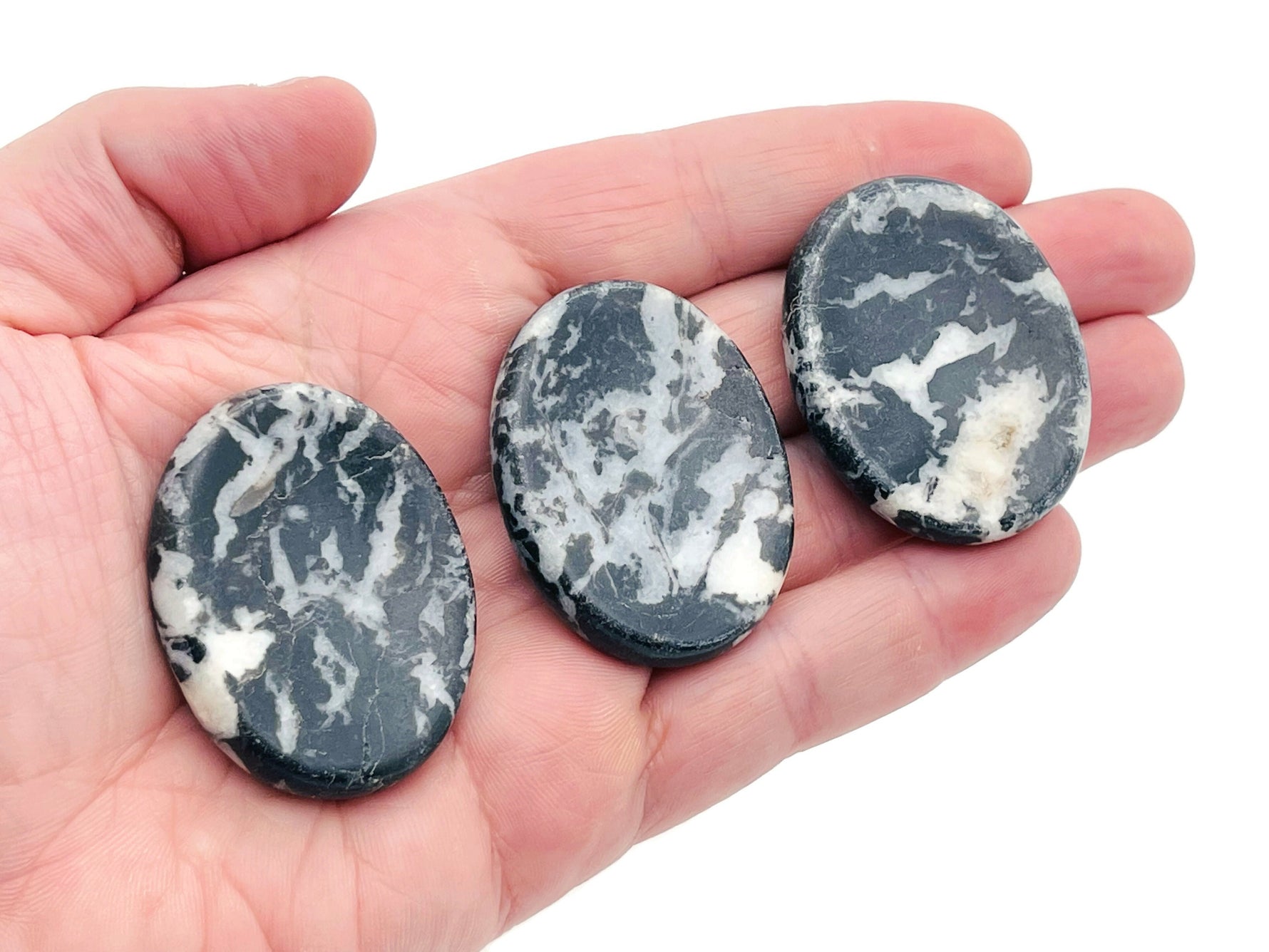 Zebra Calcite worry stone from GemstoneGO, smooth 4.5x3.5cm crystal with black and white striped pattern for soothing grip.