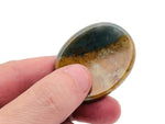 Moss Agate worry stone from GemstoneGO, soothing crystal with green and brown patterns, measuring 4.5x3.5cm on a white background.