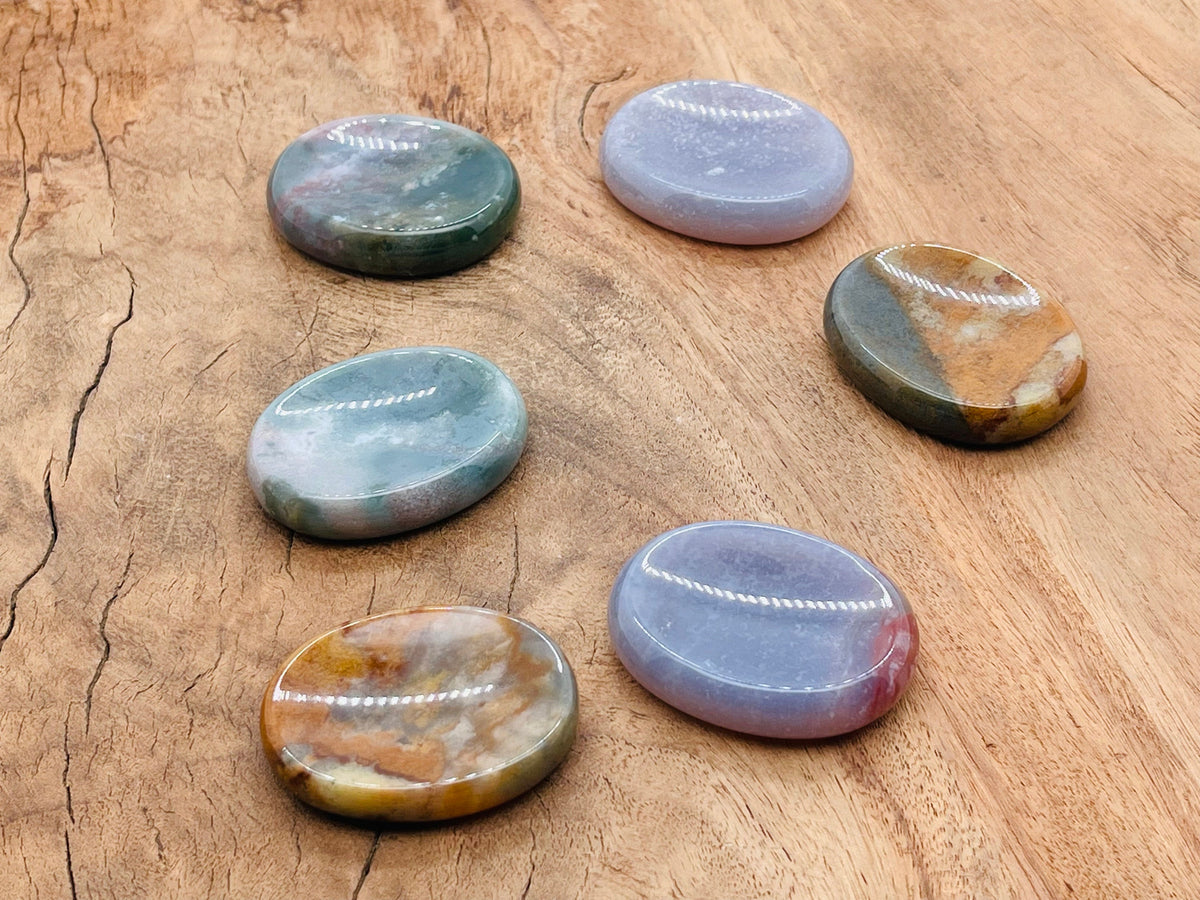 Moss agate worry stone with green and brown patterns, smooth 4.5x3.5cm gemstone for calming and meditation.