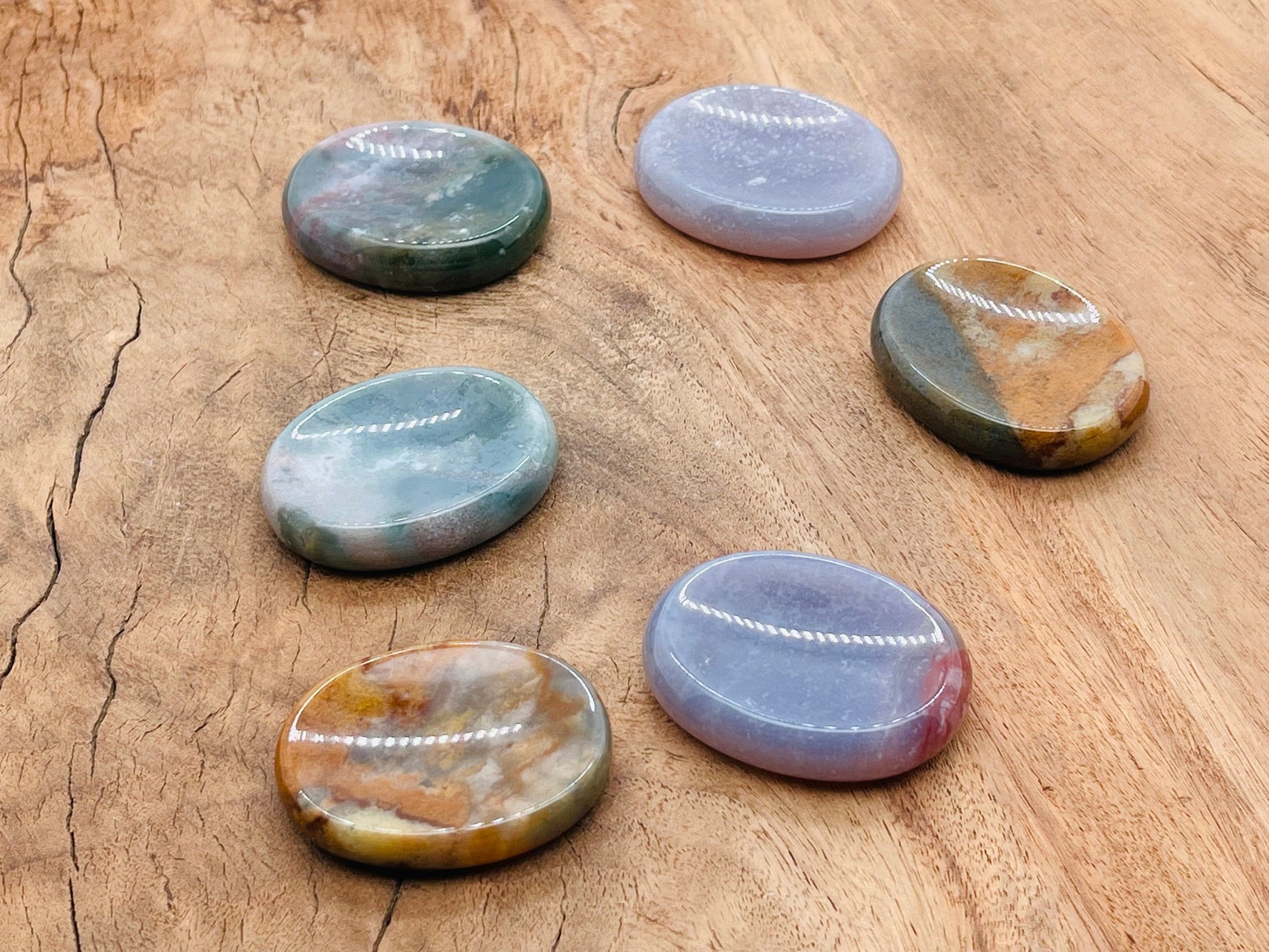 Moss agate worry stone with green and brown patterns, smooth 4.5x3.5cm gemstone for calming and meditation.