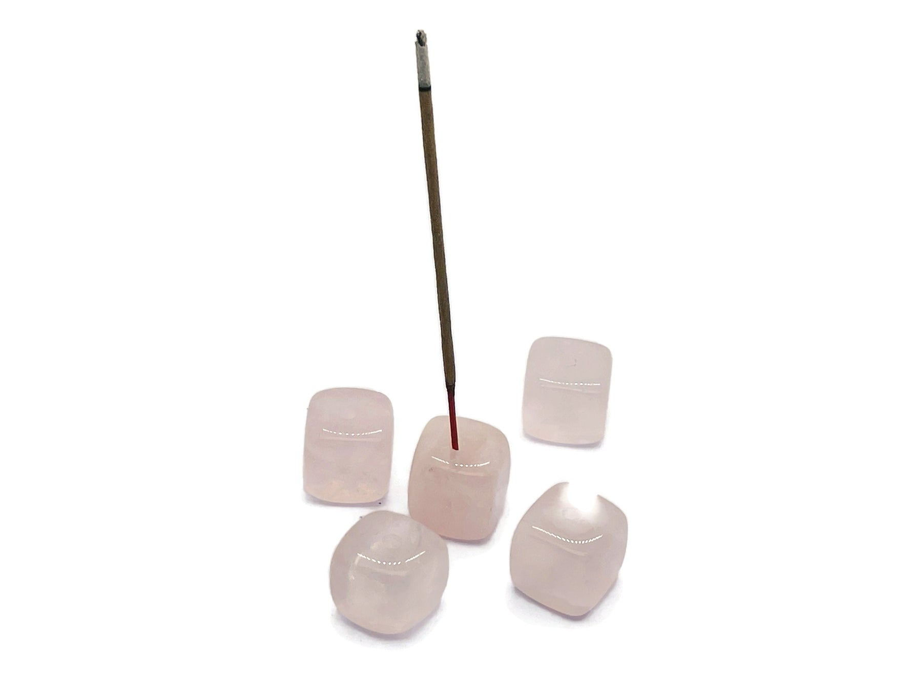 Handmade rose quartz crystal incense holder with carved details, designed for holding incense sticks gracefully.