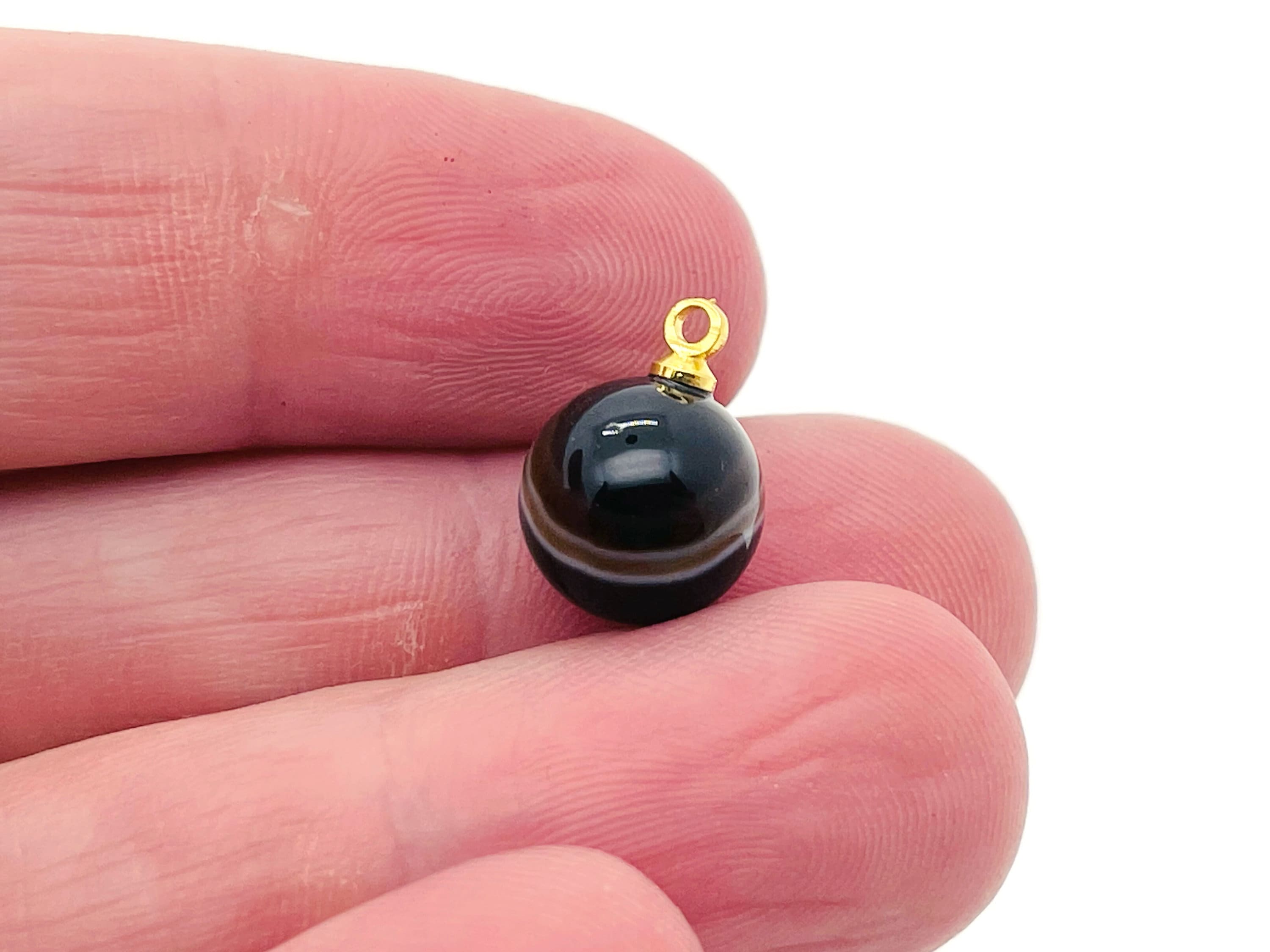 Black agate ball beads with crystal pendant, showcasing smooth round jewelry stones from GemstoneGO.