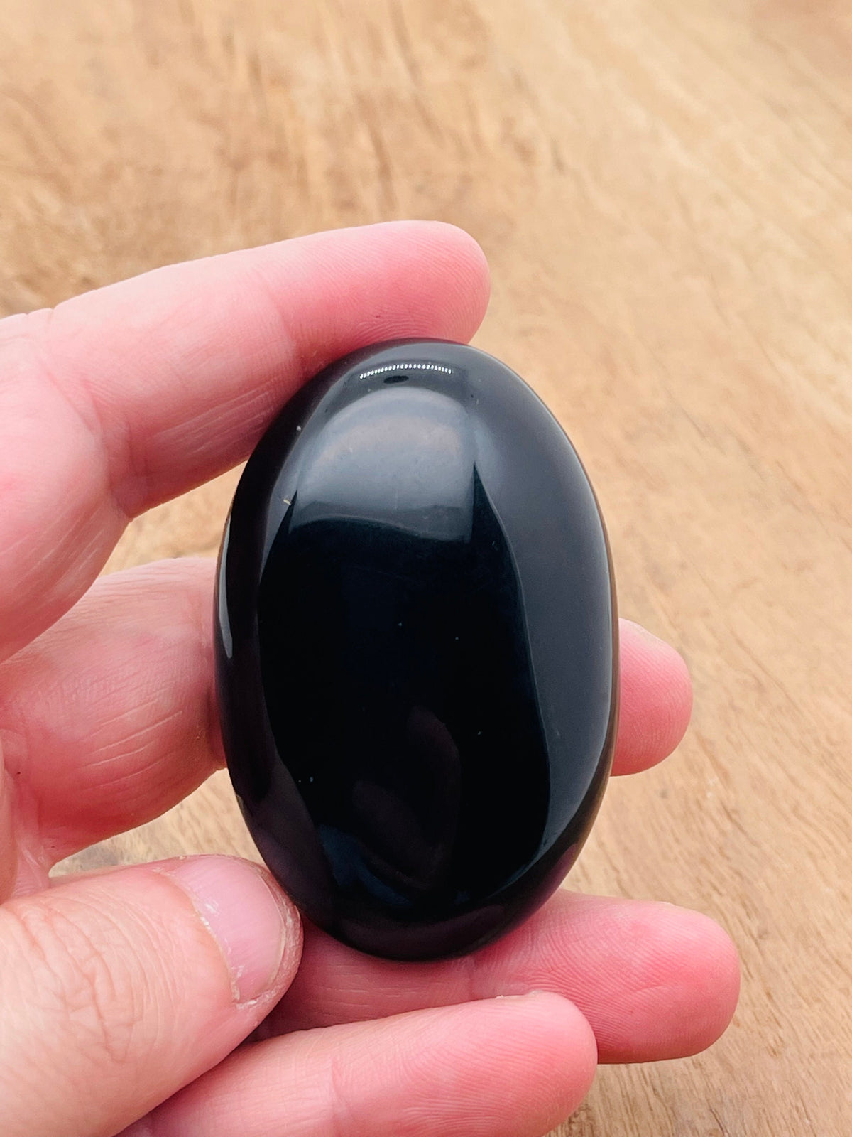 Obsidian palm gemstone spa stone, 60x40mm, from GemstoneGO, showing smooth, polished black volcanic stone for therapeutic use.
