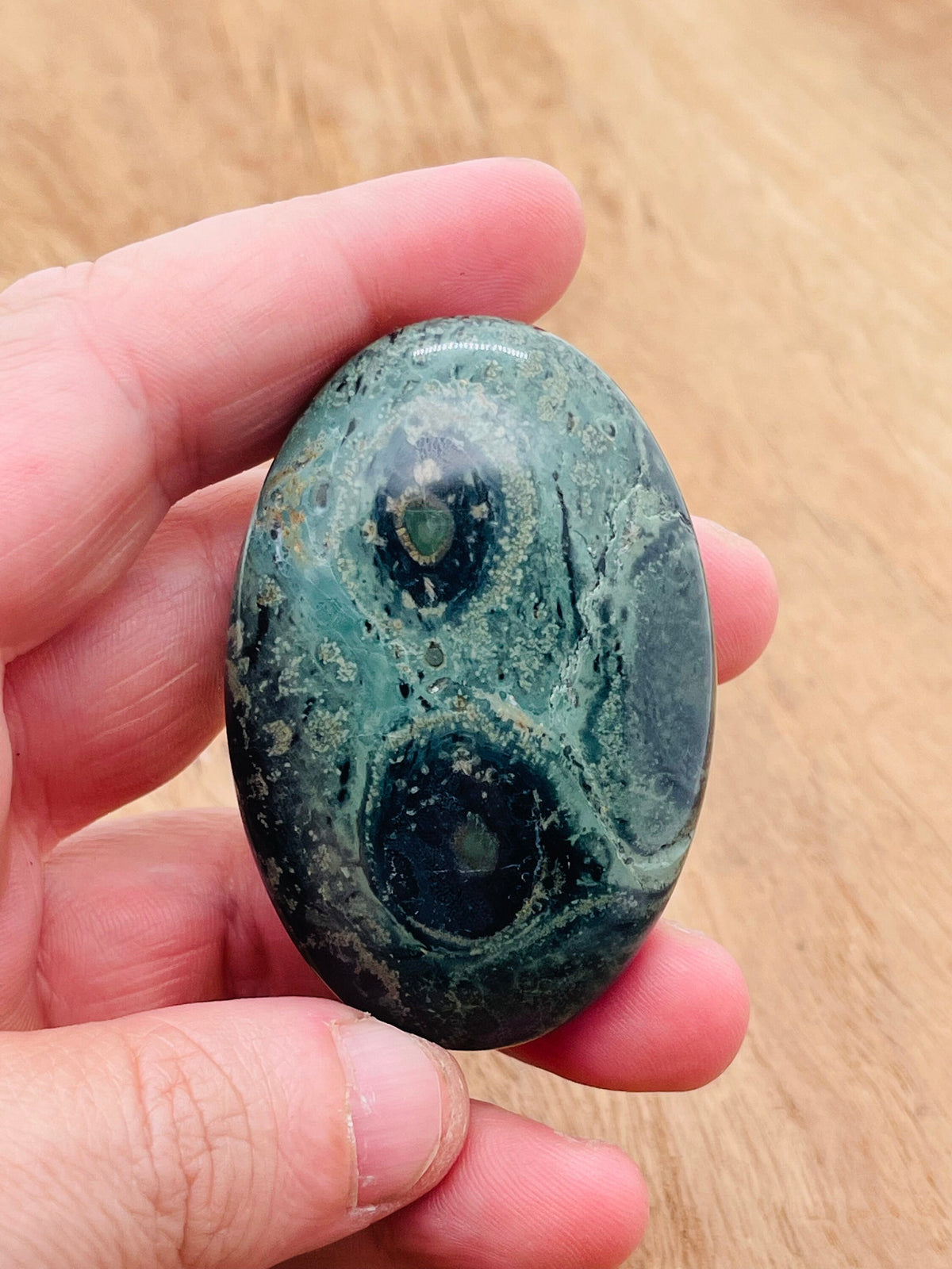 Kambaba Jasper palm gemstone spa stone, 60x40mm, smooth round shape with green and black swirling patterns, from GemstoneGO.