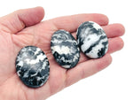 Zebra Calcite palm gemstone spa stone, 45x35mm, with distinctive black and white striped pattern, natural mineral specimen.