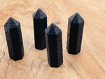 Lava volcanic obelisk tower crystal from GemstoneGO, showcasing deep red and black volcanic stone with natural textures.