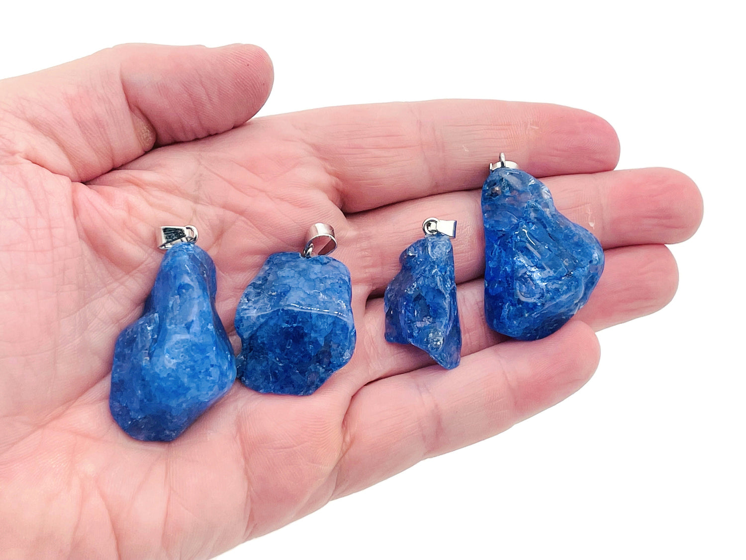 Blue agate crystal pendant with silver bail, showcasing its polished, vibrant blue stone and natural banding details.