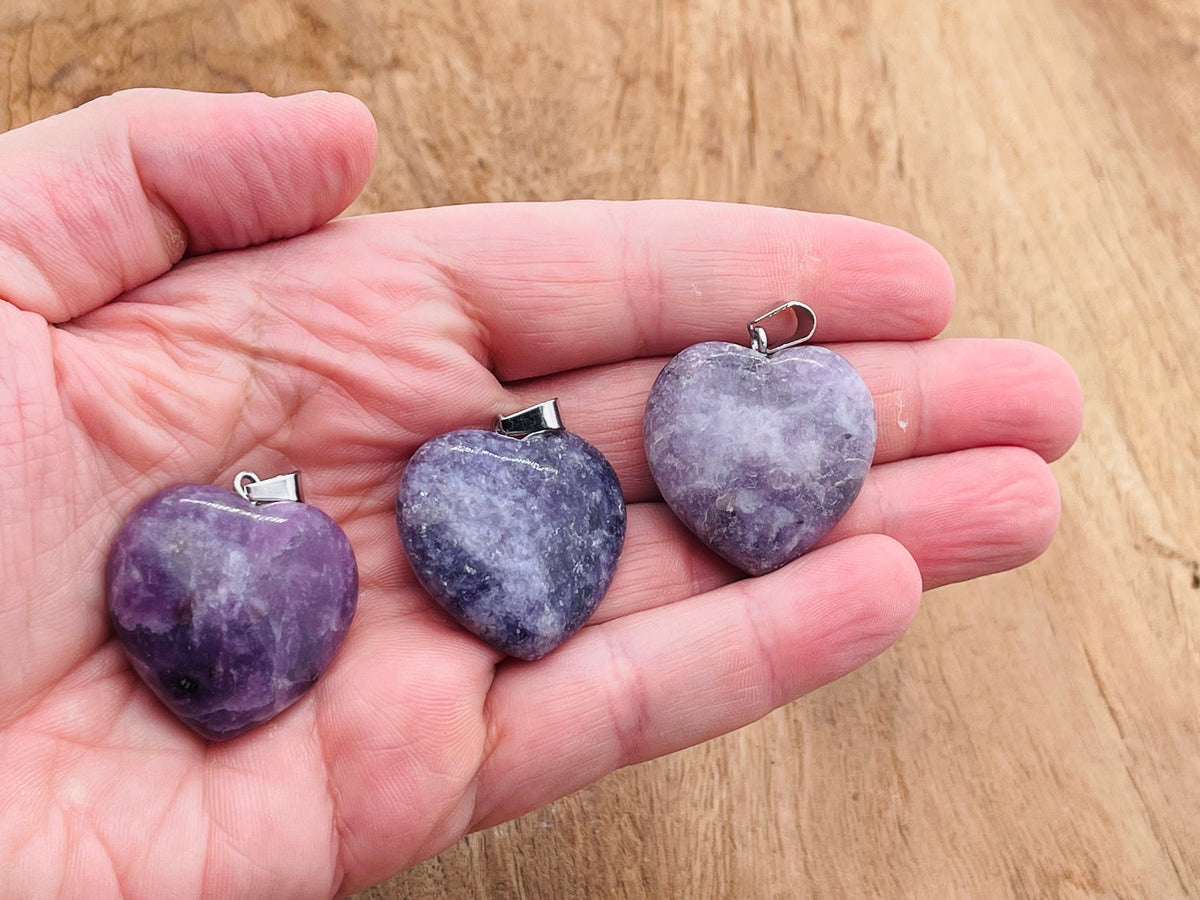 Lepidolite heart crystal pendant from GemstoneGO, showcasing a polished, purple gemstone with silver chain detail.