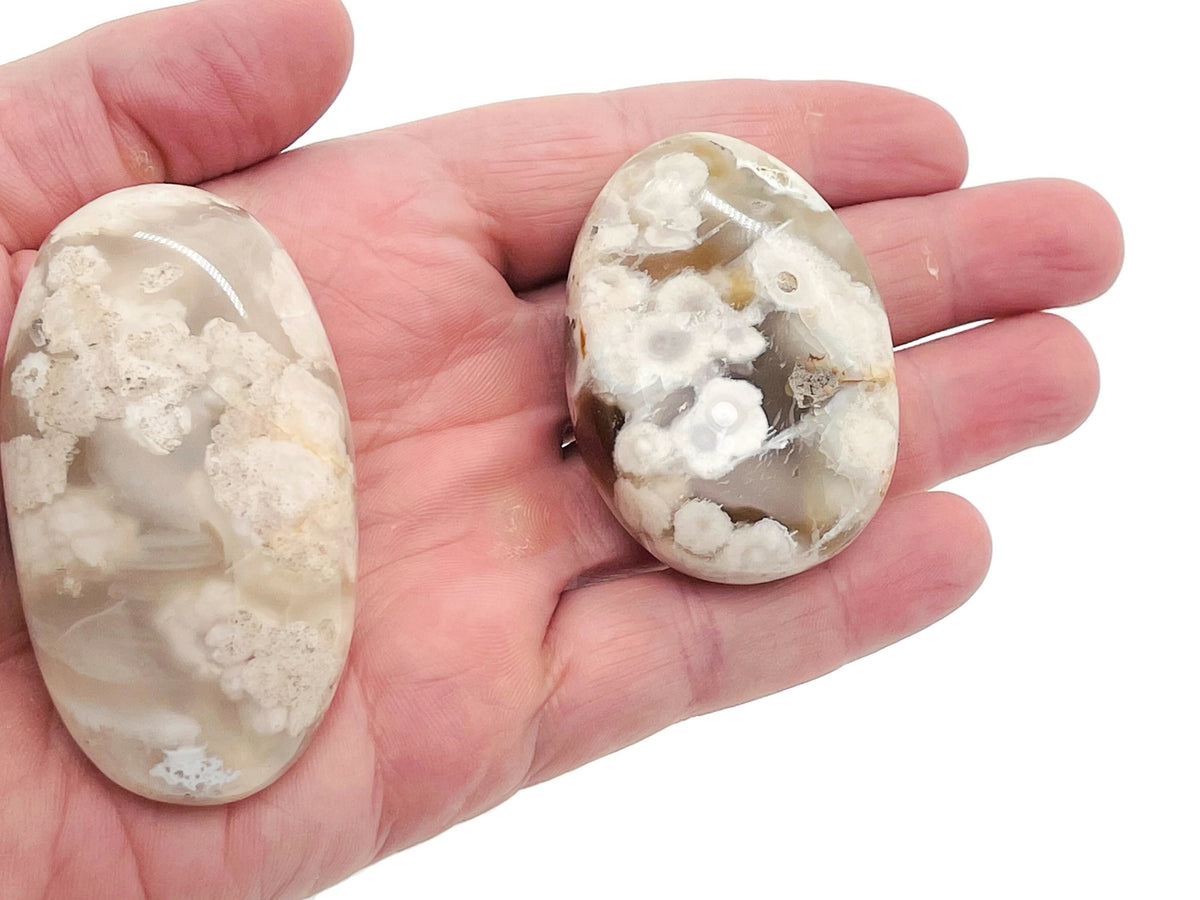 Flower Agate palm gemstone spa stone with cherry blossom patterns, showcasing vibrant pink and white floral details.