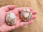 Flower Agate palm gemstone spa stone with cherry blossom design, showcasing vibrant pink and white floral patterns.