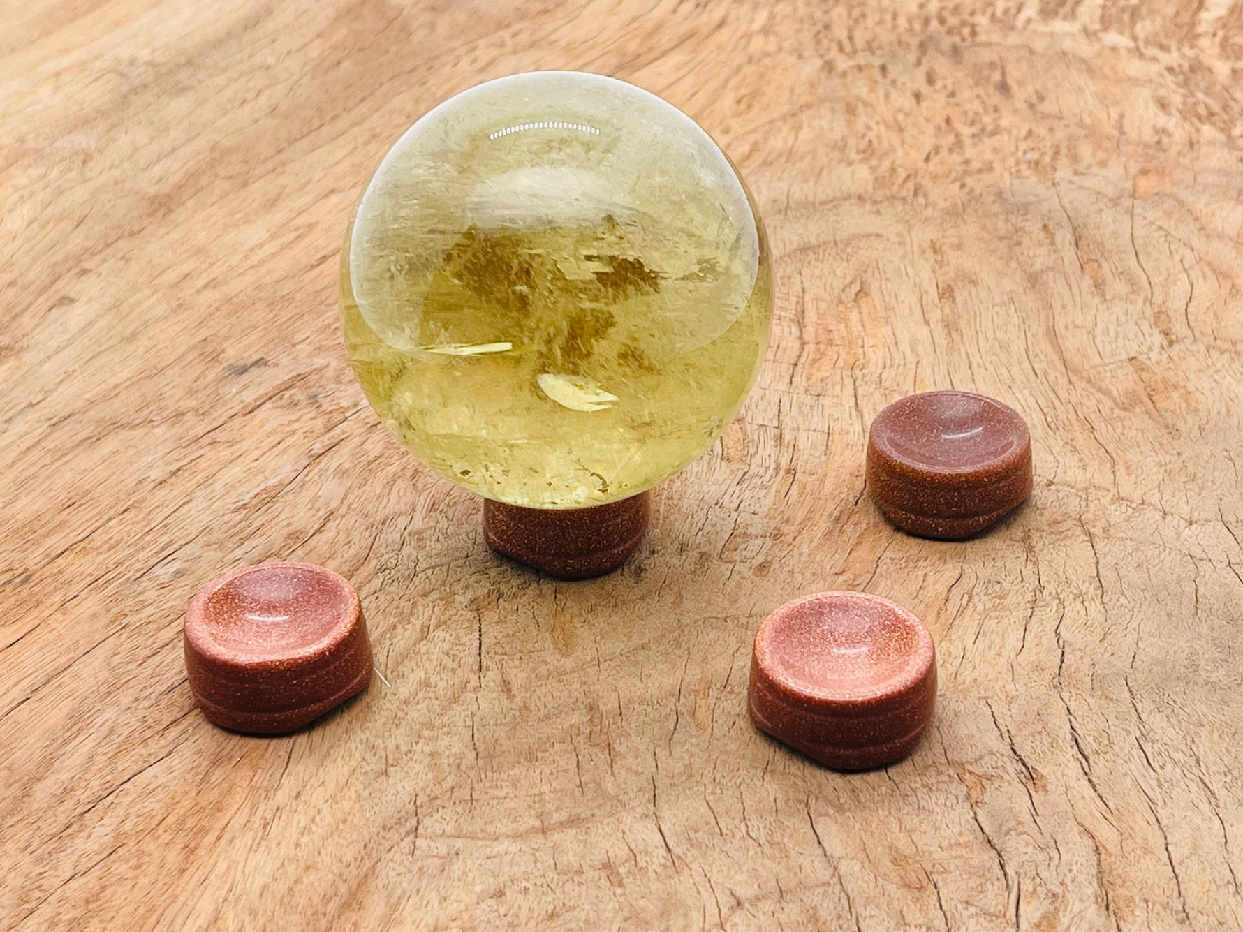 Goldstone crystal sphere on carved gemstone stand, decorative home decor piece showcasing shimmering gold and deep hues.