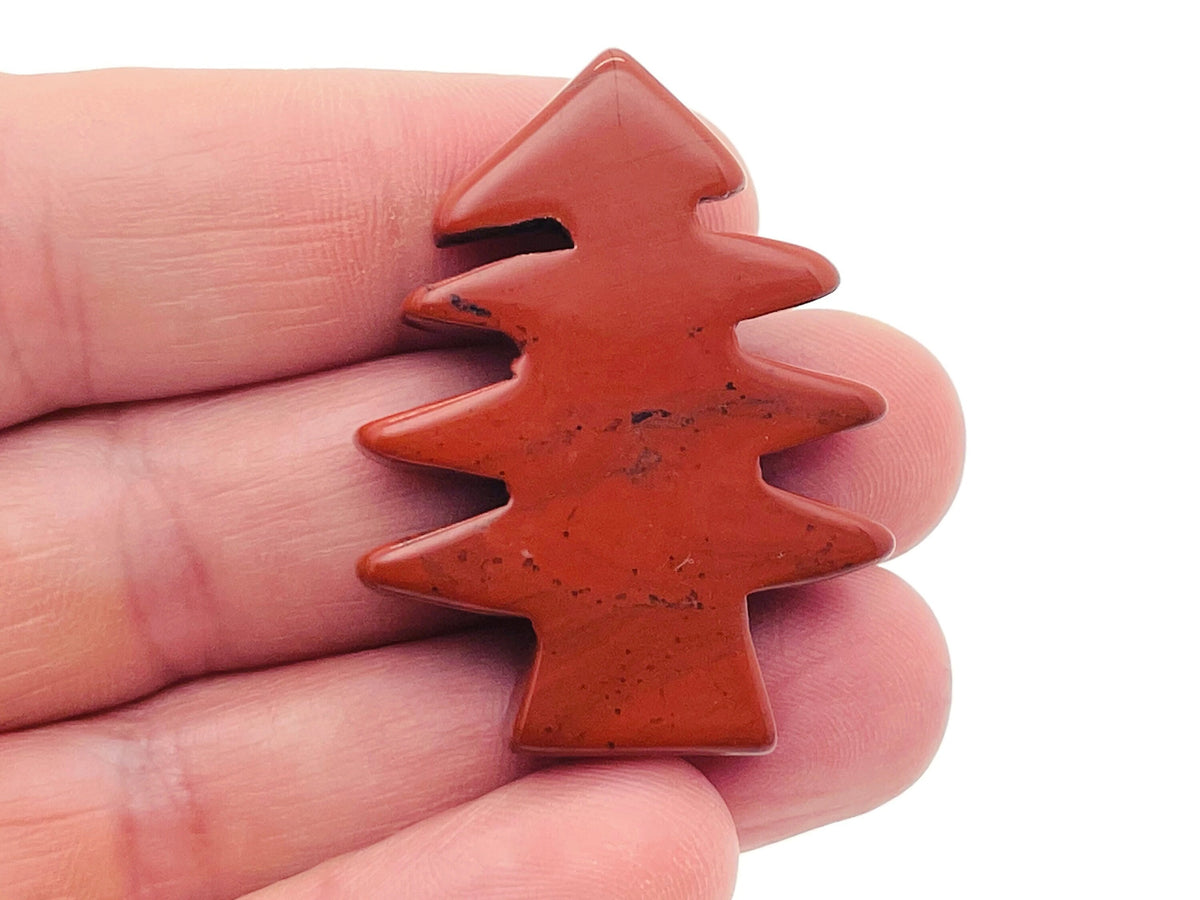 Handmade red jasper pine tree gemstone carving, detailed natural stone sculpture of a pine tree with vibrant red hues.