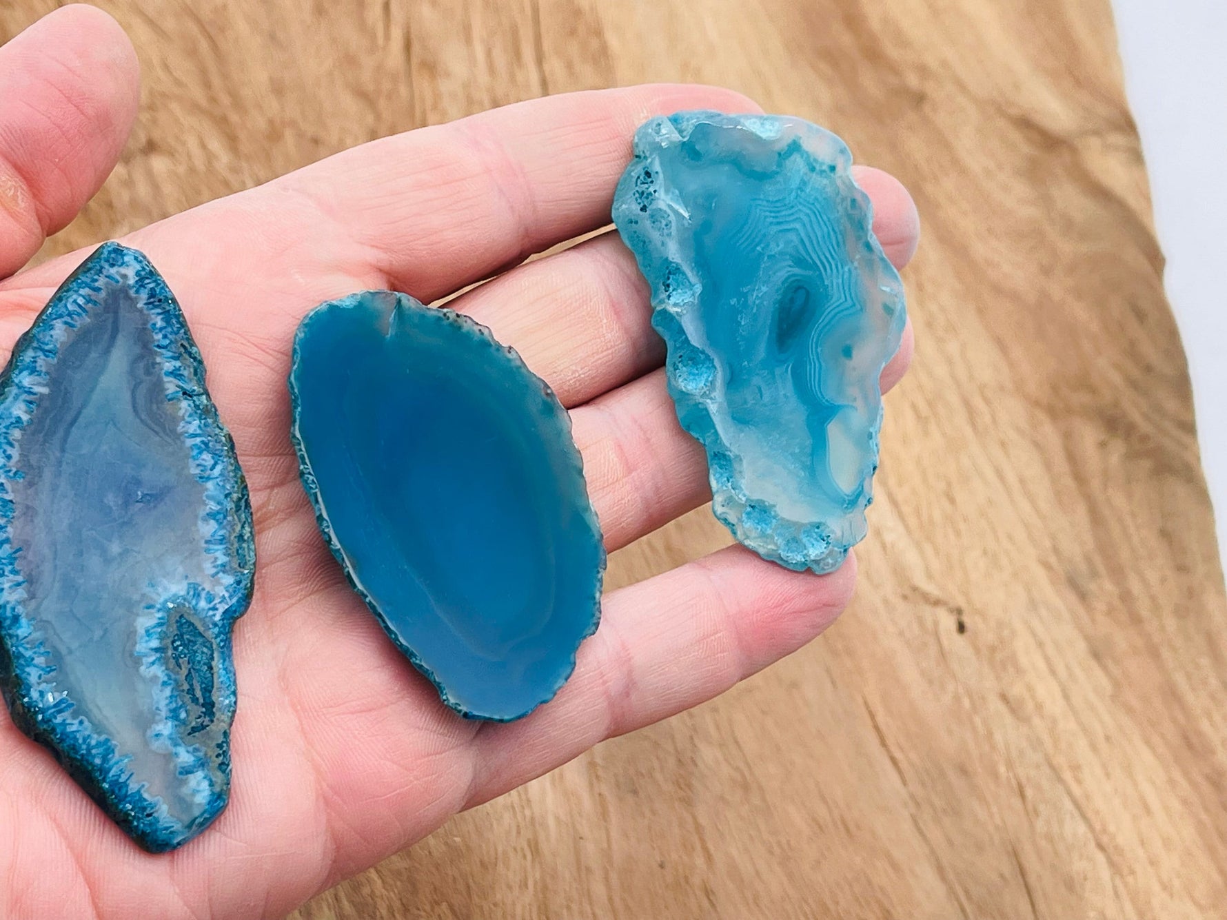 Blue Agate geode slice from GemstoneGO, showcasing vibrant blue banding and raw crystal formation on a natural stone surface.