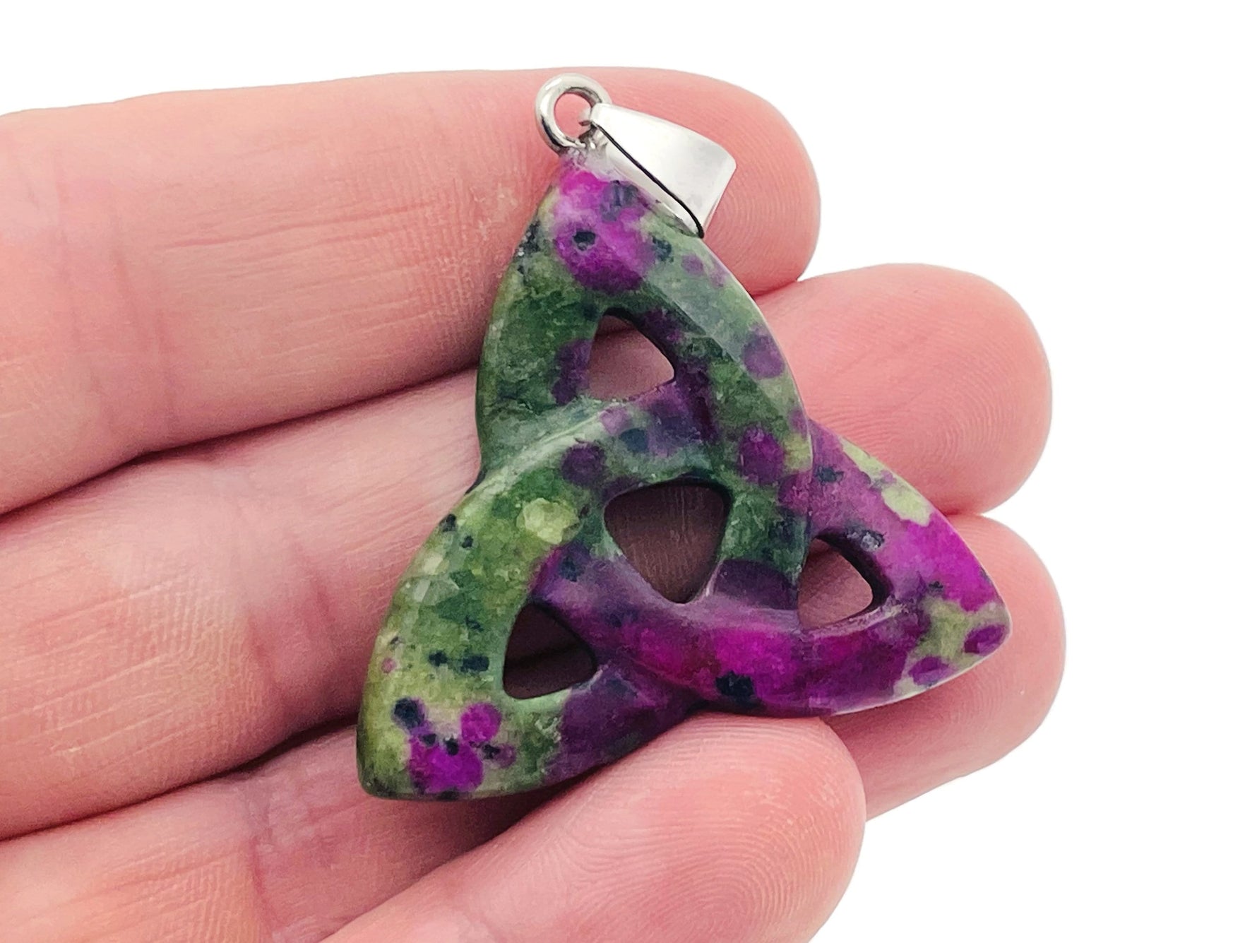 Ruby Zoisite Celtic Knot crystal pendant by GemstoneGO featuring a Trinity Crystals design and intricate Celtic knot detailing.