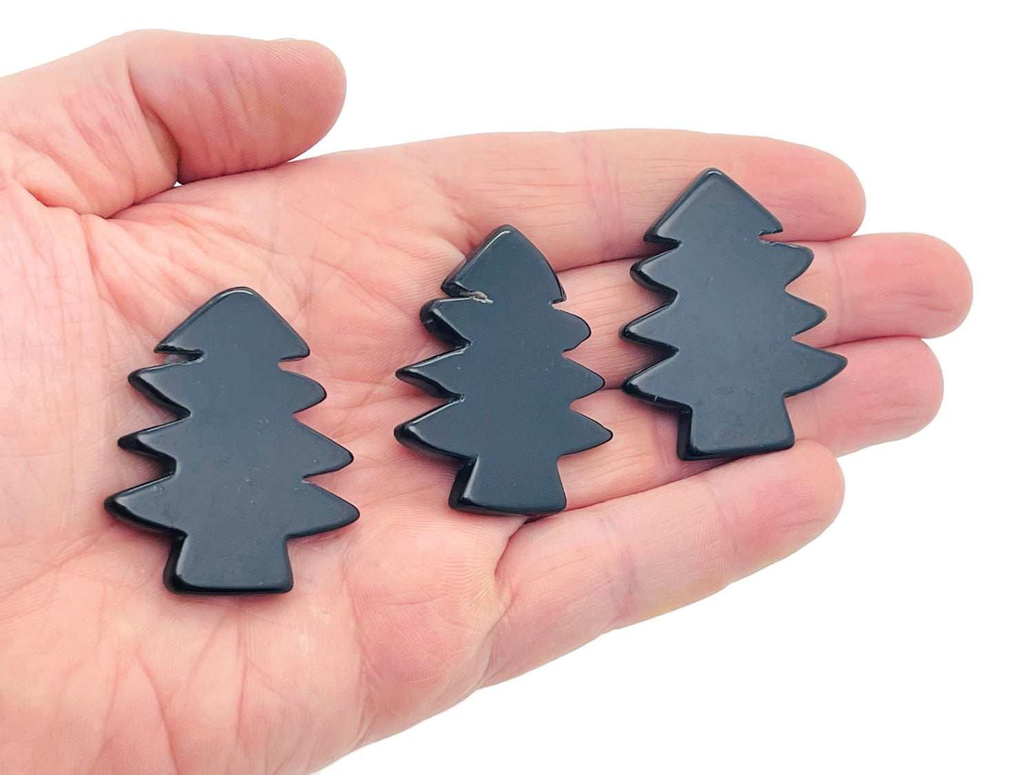Handmade obsidian pine tree gemstone carving with detailed tree design, showcasing natural black stone texture and craftsmanship.