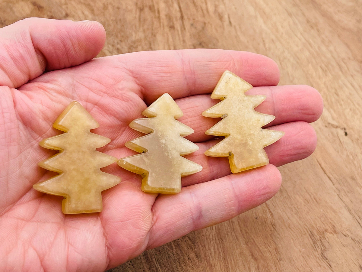 Handmade yellow aventurine gemstone carving of a pine tree, showcasing detailed craftsmanship and vibrant natural stone.