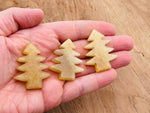 Handmade yellow aventurine gemstone carving of a pine tree, showcasing detailed craftsmanship and vibrant natural stone.