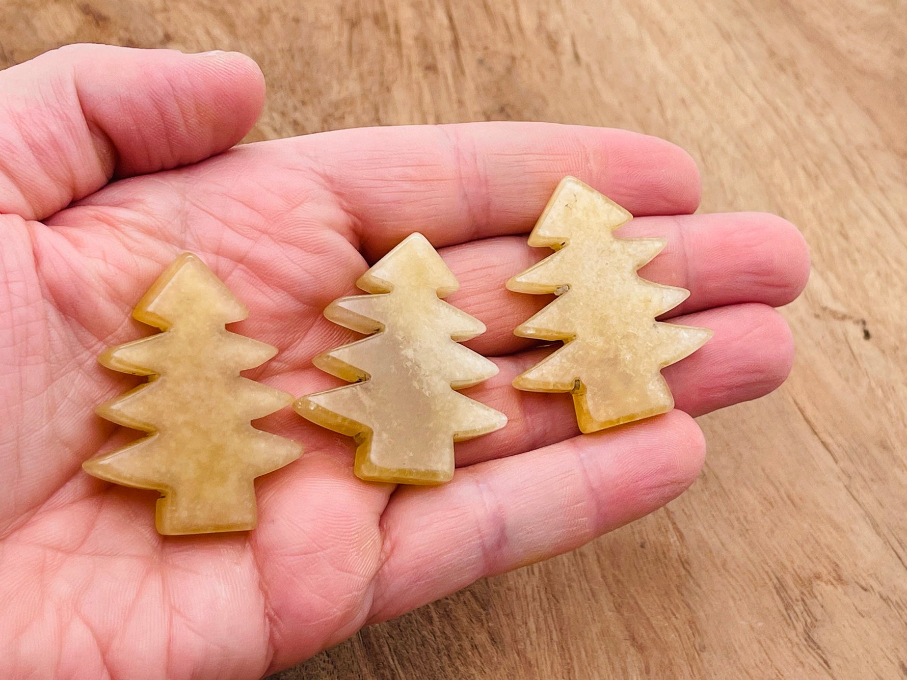 Handmade yellow aventurine gemstone carving of a pine tree, showcasing detailed craftsmanship and vibrant natural stone.