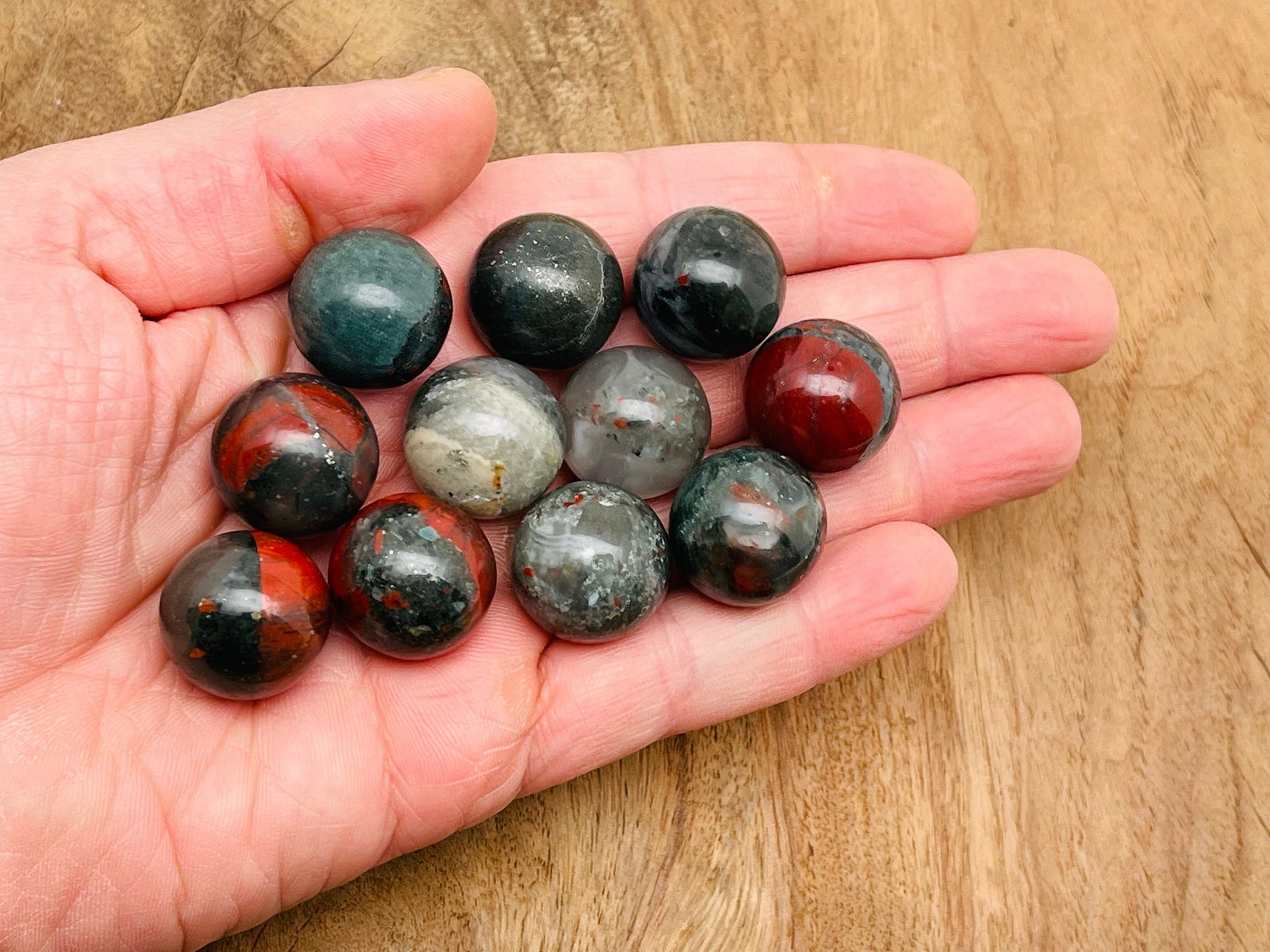 20mm African Bloodstone sphere gemstone from GemstoneGO, polished crystal ball showcasing deep green and red mineral patterns.