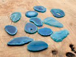 Blue agate slice gemstone from GemstoneGO, showing a vibrant raw crystal geode with natural banding and textured surface.