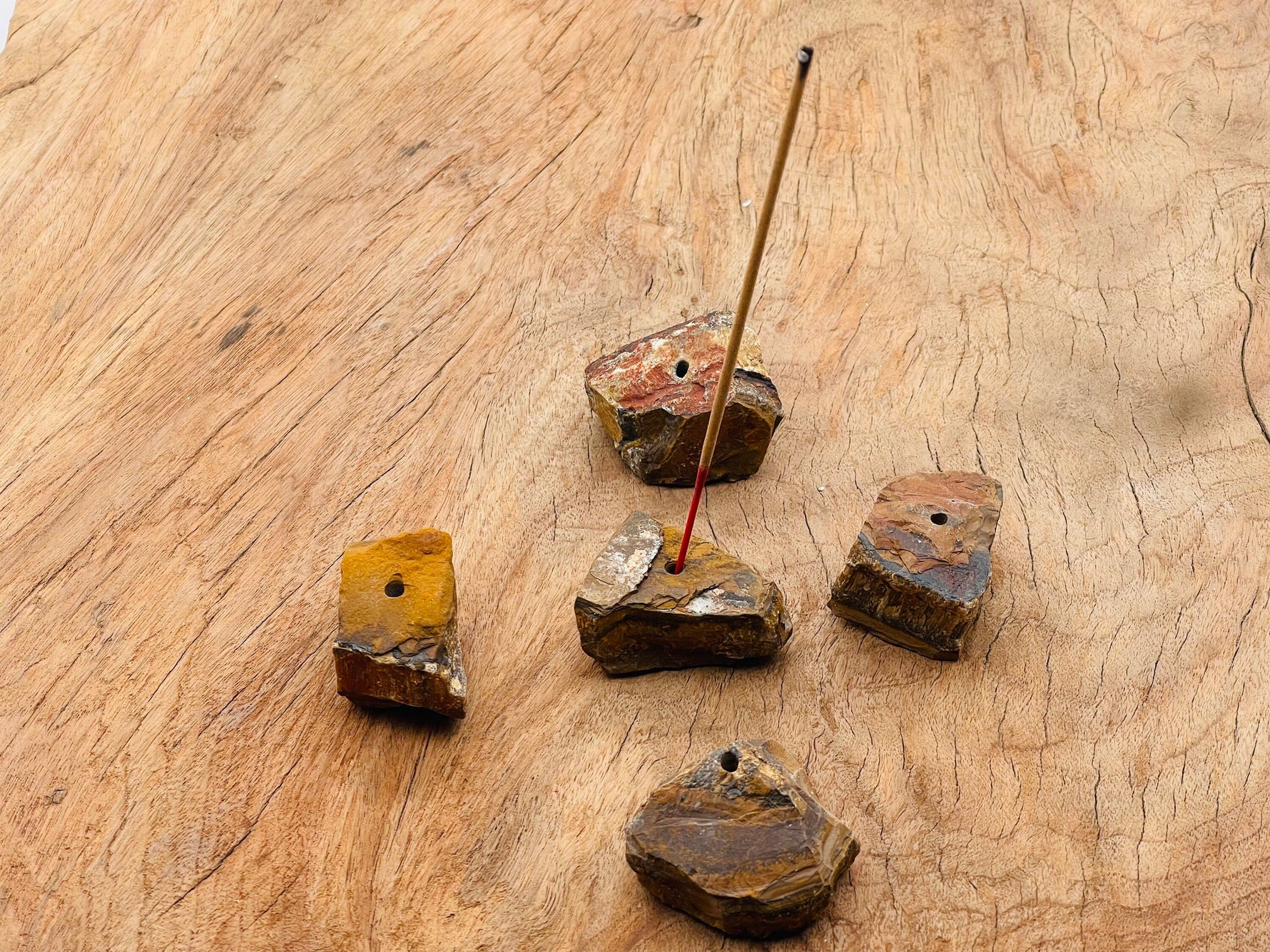 Handmade tiger eye rough crystal incense holder with carved design, perfect for holding incense sticks.