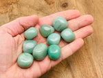 Aventurine tumbled stone from GemstoneGO, smooth polished green mineral with natural patterns, on a plain background.