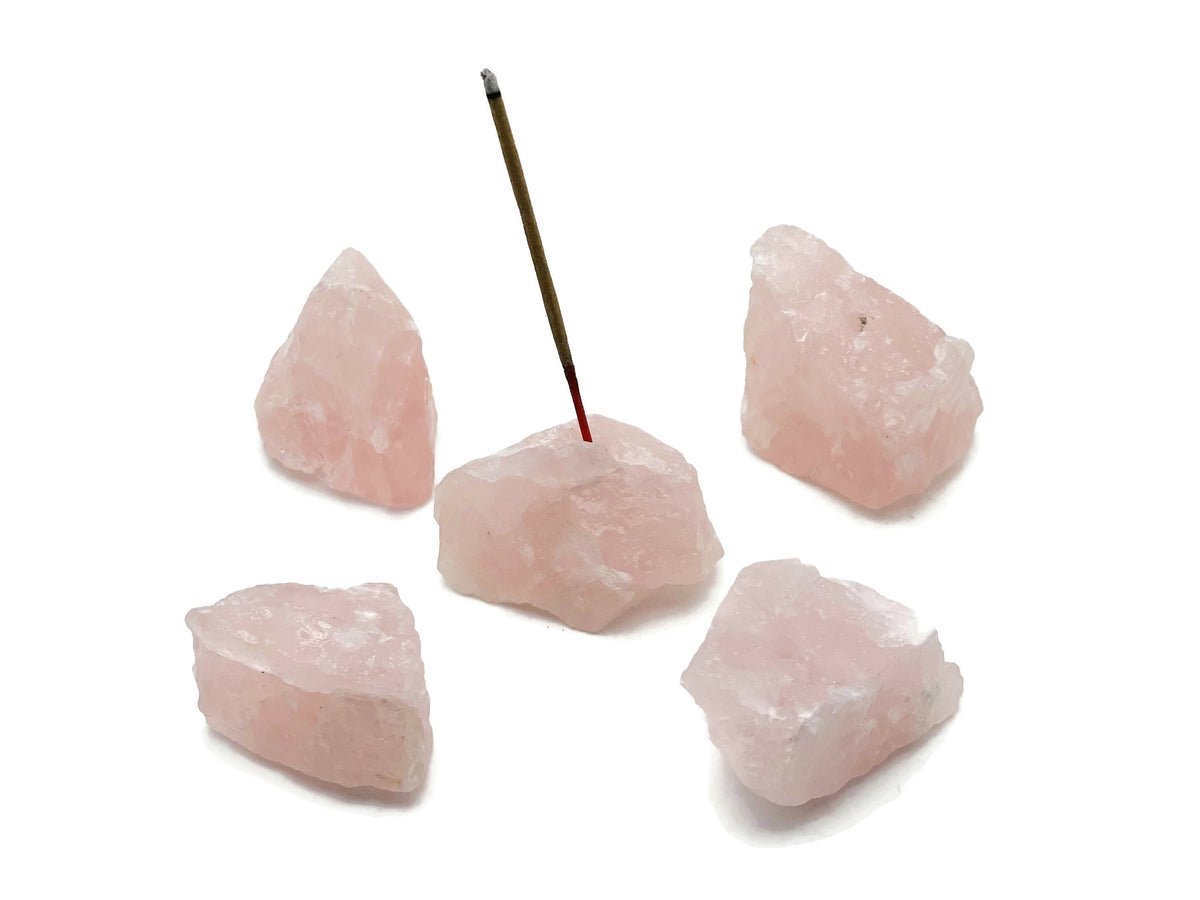 Handmade rose quartz crystal incense holder with carved design for incense sticks, showcasing a natural pink gemstone aesthetic.