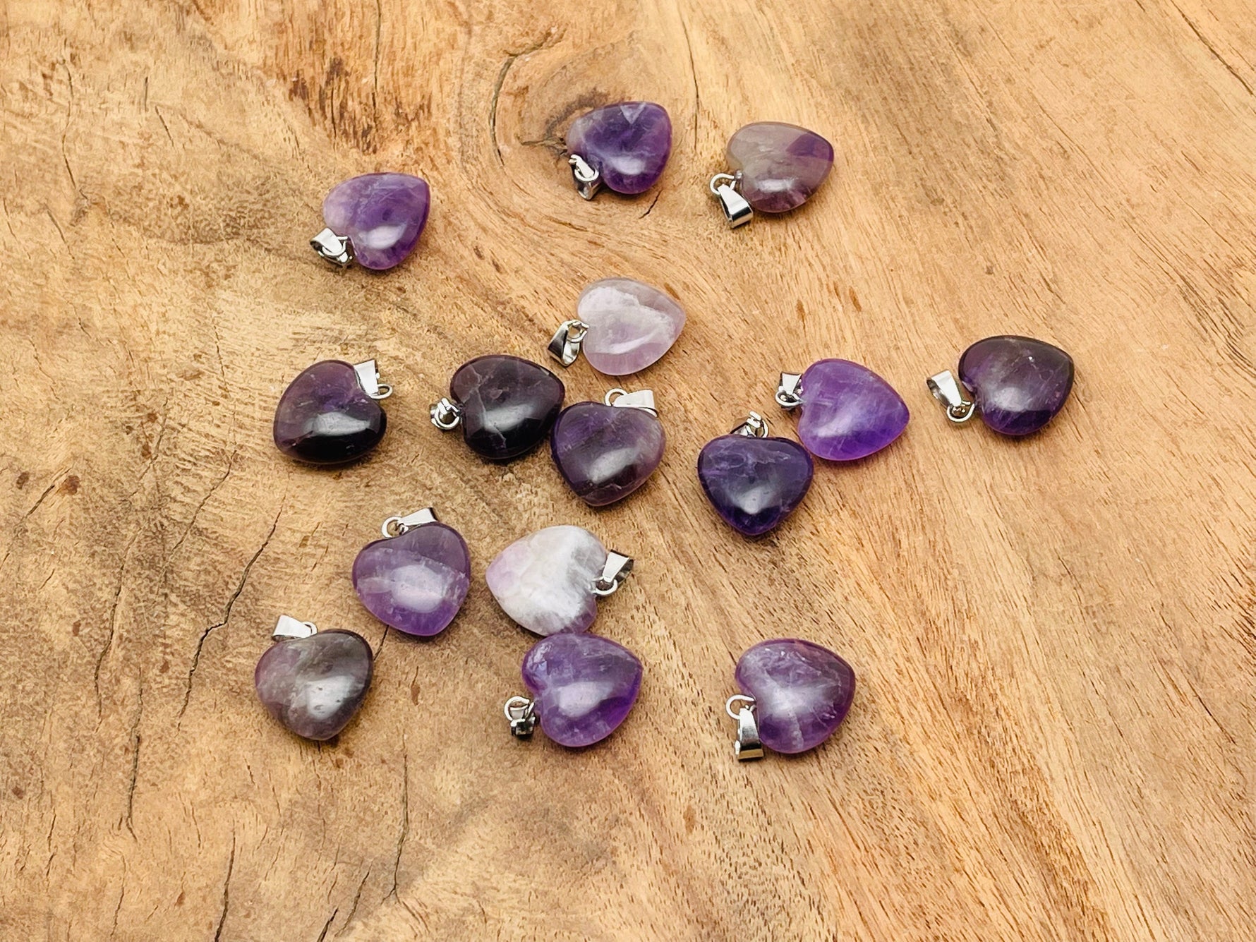 Mini amethyst heart pendant from GemstoneGO featuring a polished purple crystal gemstone on a delicate chain.