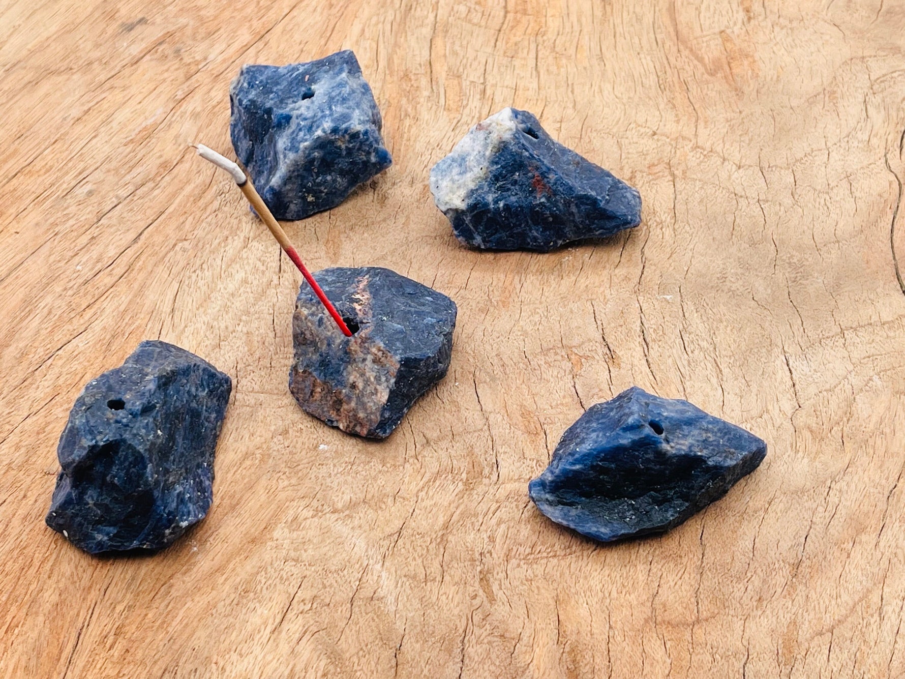Handmade sodalite rough crystal incense holder with carved design, ideal for holding incense sticks in a decorative display.