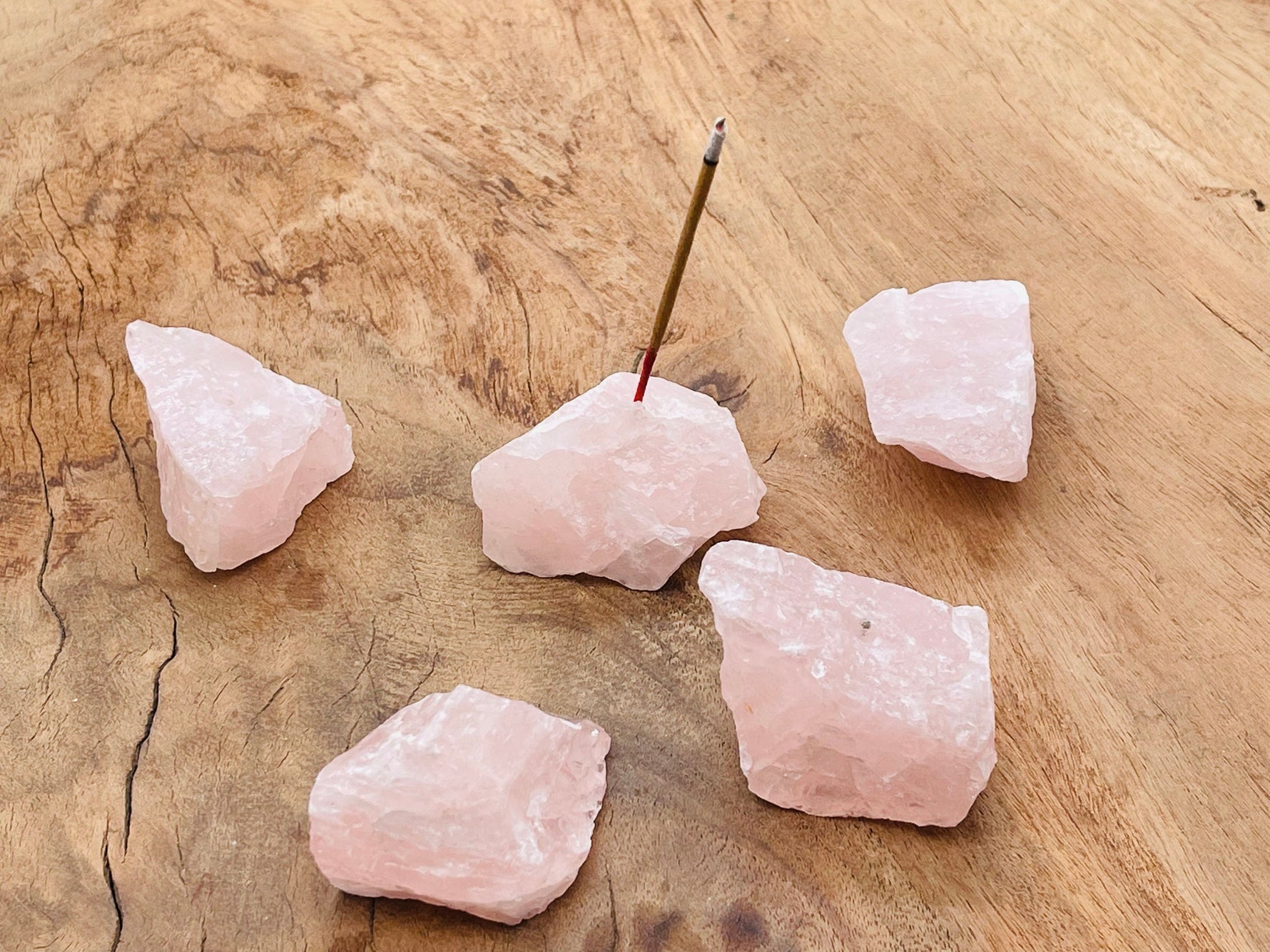 Handmade rose quartz rough crystal incense holder with carved design, ideal for holding incense sticks and enhancing decor.