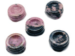 Rhodonite crystal sphere on carved gemstone stand, decorative home decor piece showcasing vibrant pink and black hues.