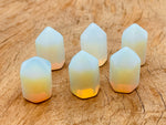 Opalite obelisk tower crystal from GemstoneGO, 25mm, showcasing smooth polished surface and translucent blue-white glow.