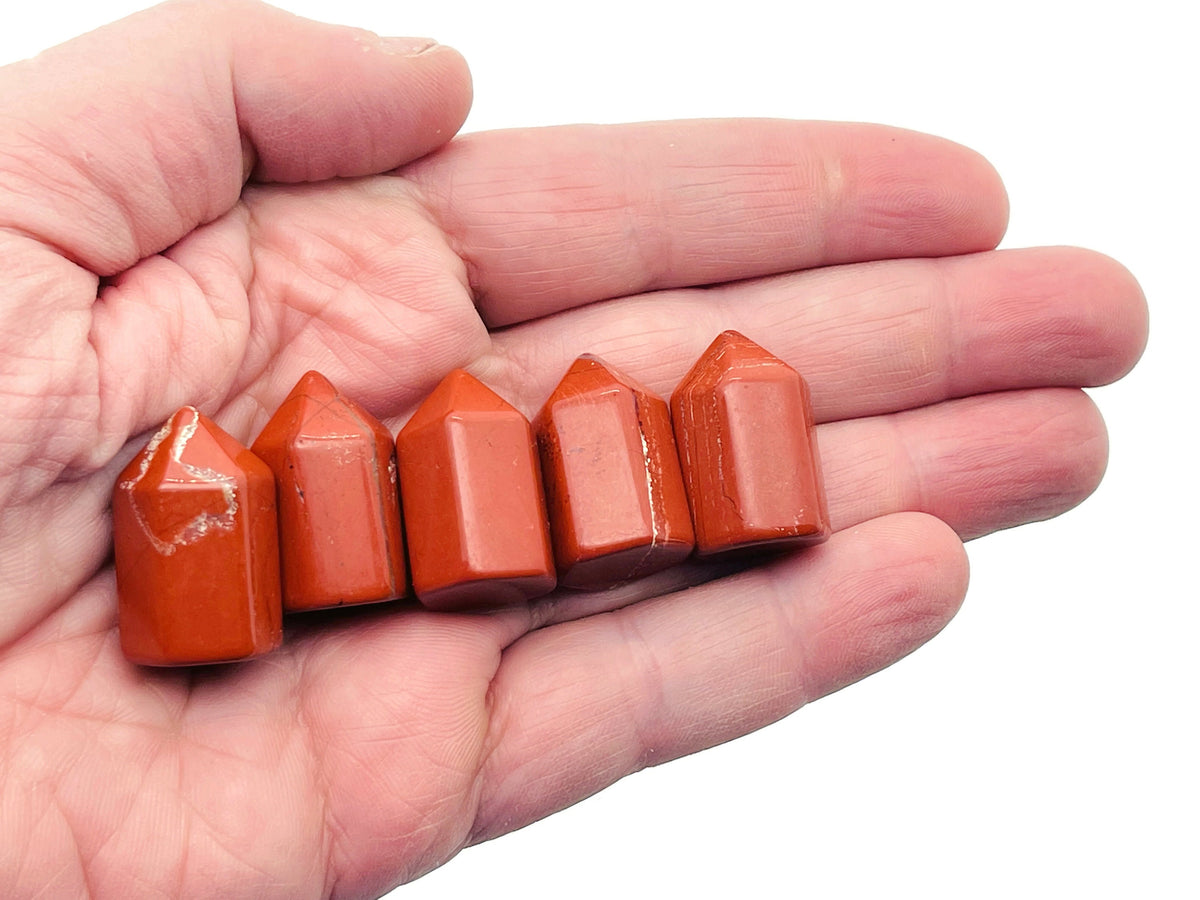 Red Jasper obelisk tower crystal from GemstoneGO, 25mm, showing a smooth, polished red stone with natural patterns and a pointed top.