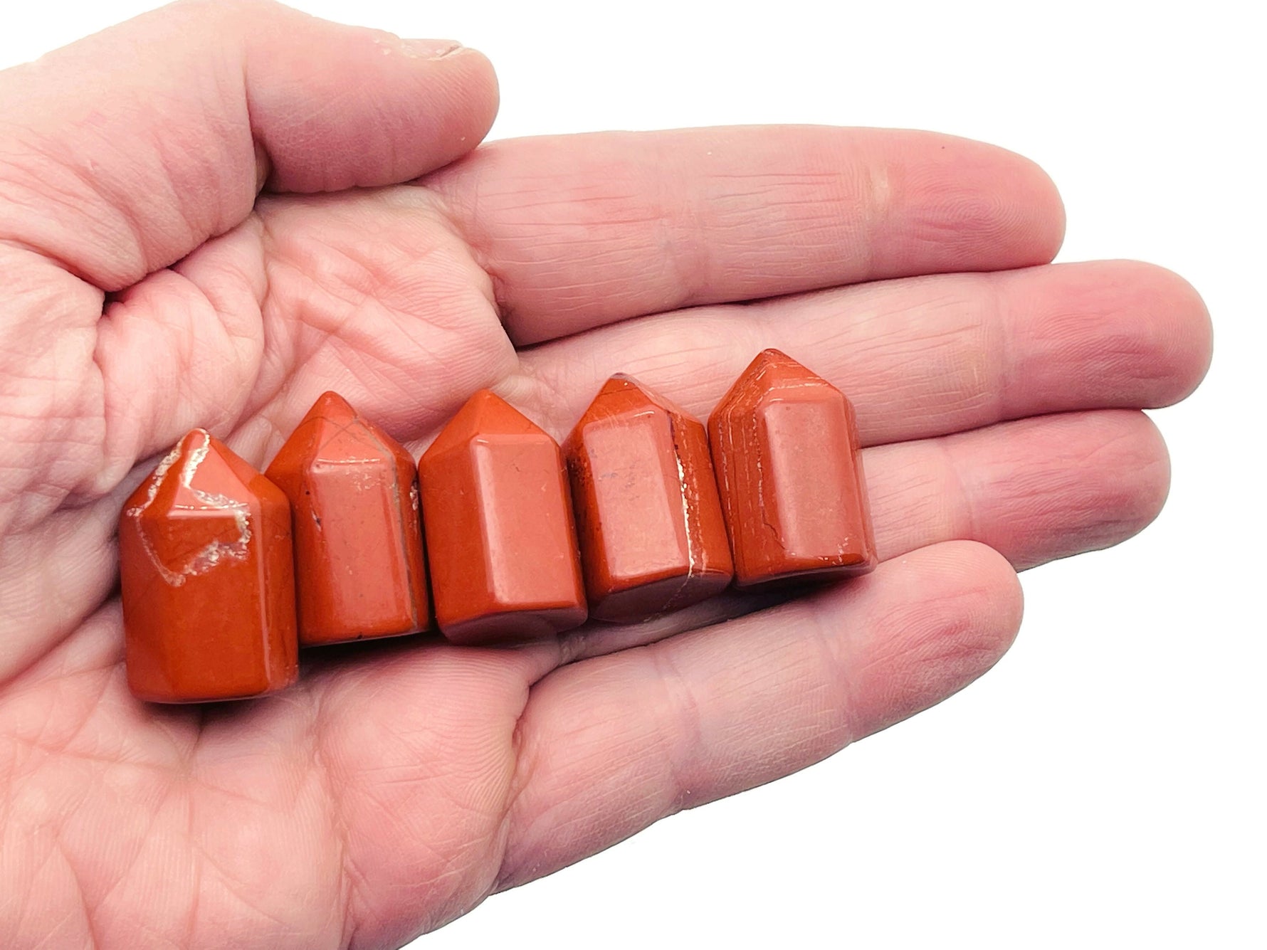 Red Jasper obelisk tower crystal from GemstoneGO, 25mm, showing a smooth, polished red stone with natural patterns and a pointed top.