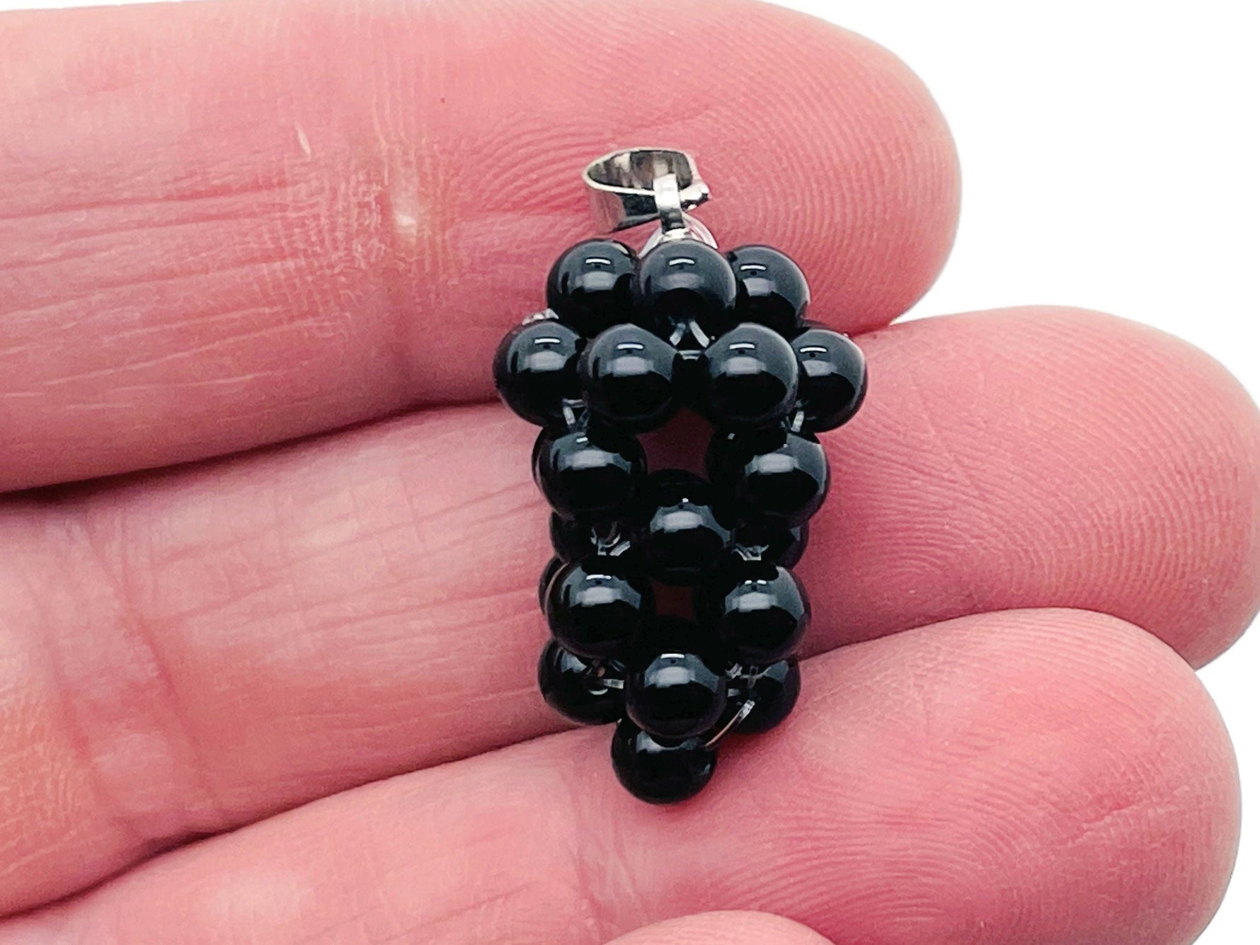 Obsidian grape crystal pendant by GemstoneGO featuring a detailed crystal grape design on a silver chain.