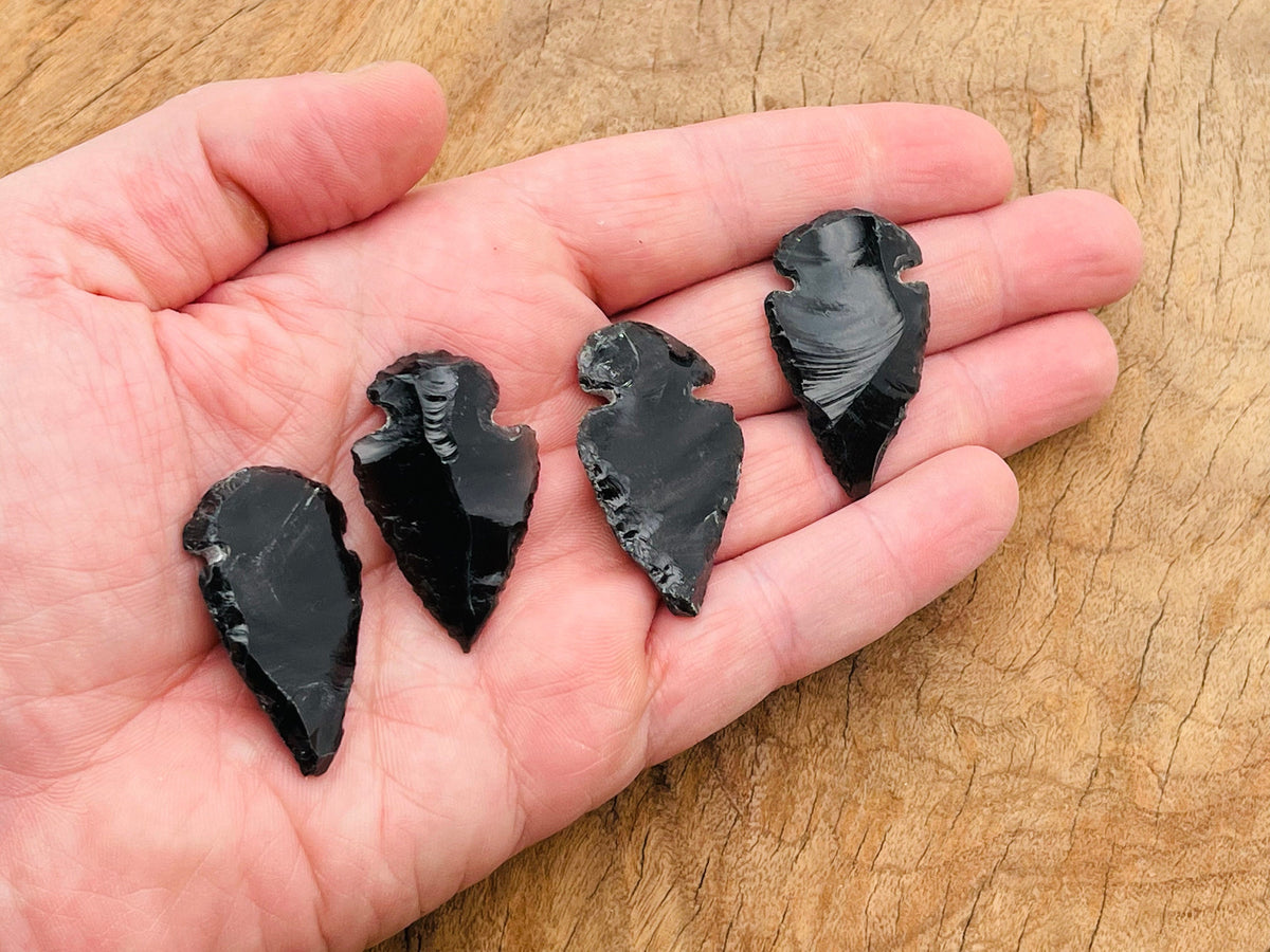 Black obsidian arrowhead carving gemstone with detailed craftsmanship, used as a spearhead or decorative piece.