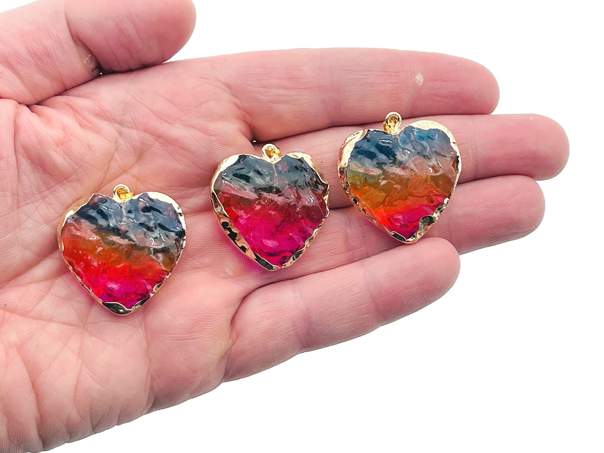 Pink, yellow, and blue rainbow aura heart crystal pendant from GemstoneGO, featuring a vibrant, loose crystal with a heart shape.