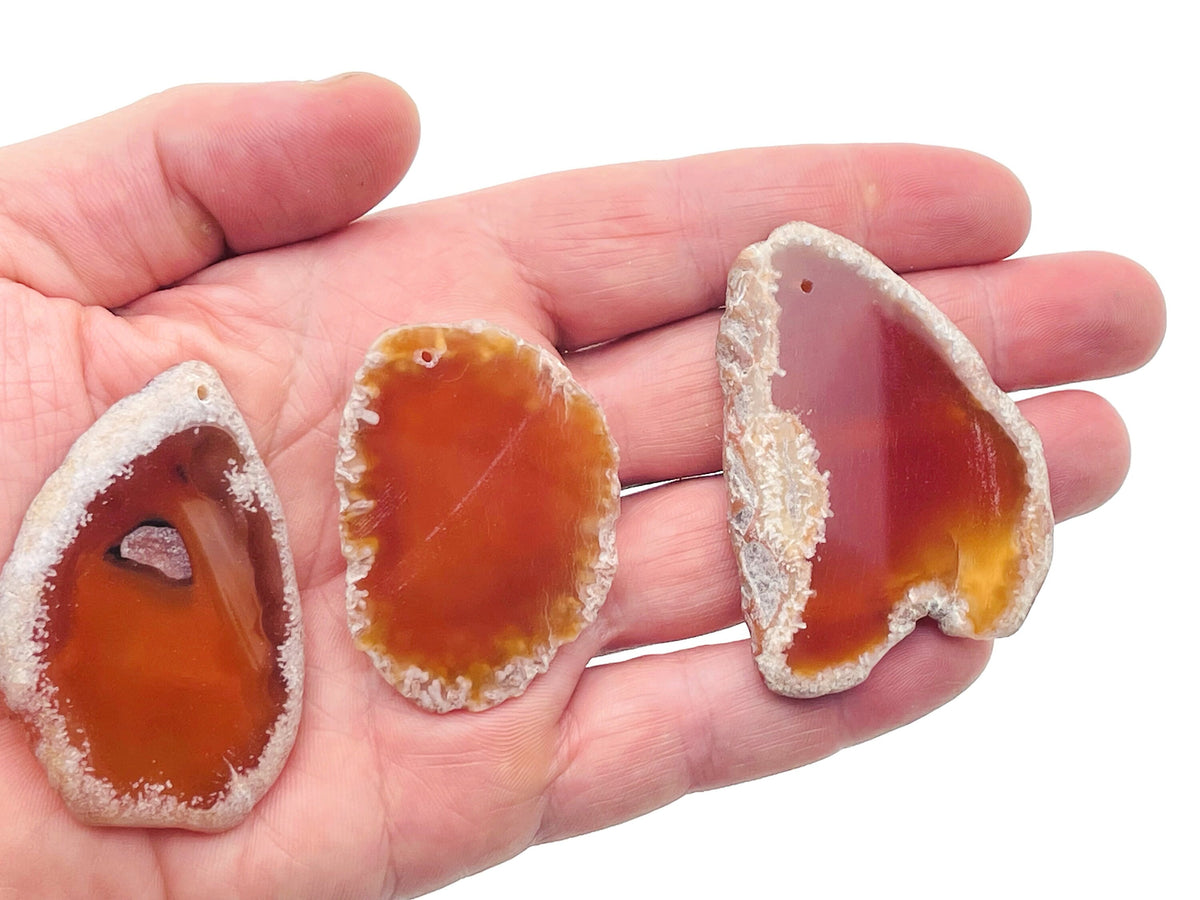 Drilled agate slice pendant with hole for jewelry making, featuring vibrant natural gemstone colors and geode crystal details.