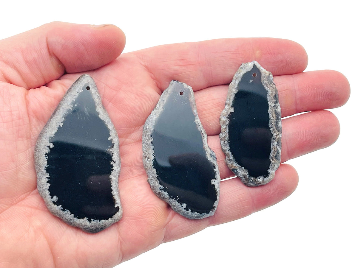 Agate slice drilled with hole, geode crystal pendant for jewelry making, featuring natural banding and gemstone details.