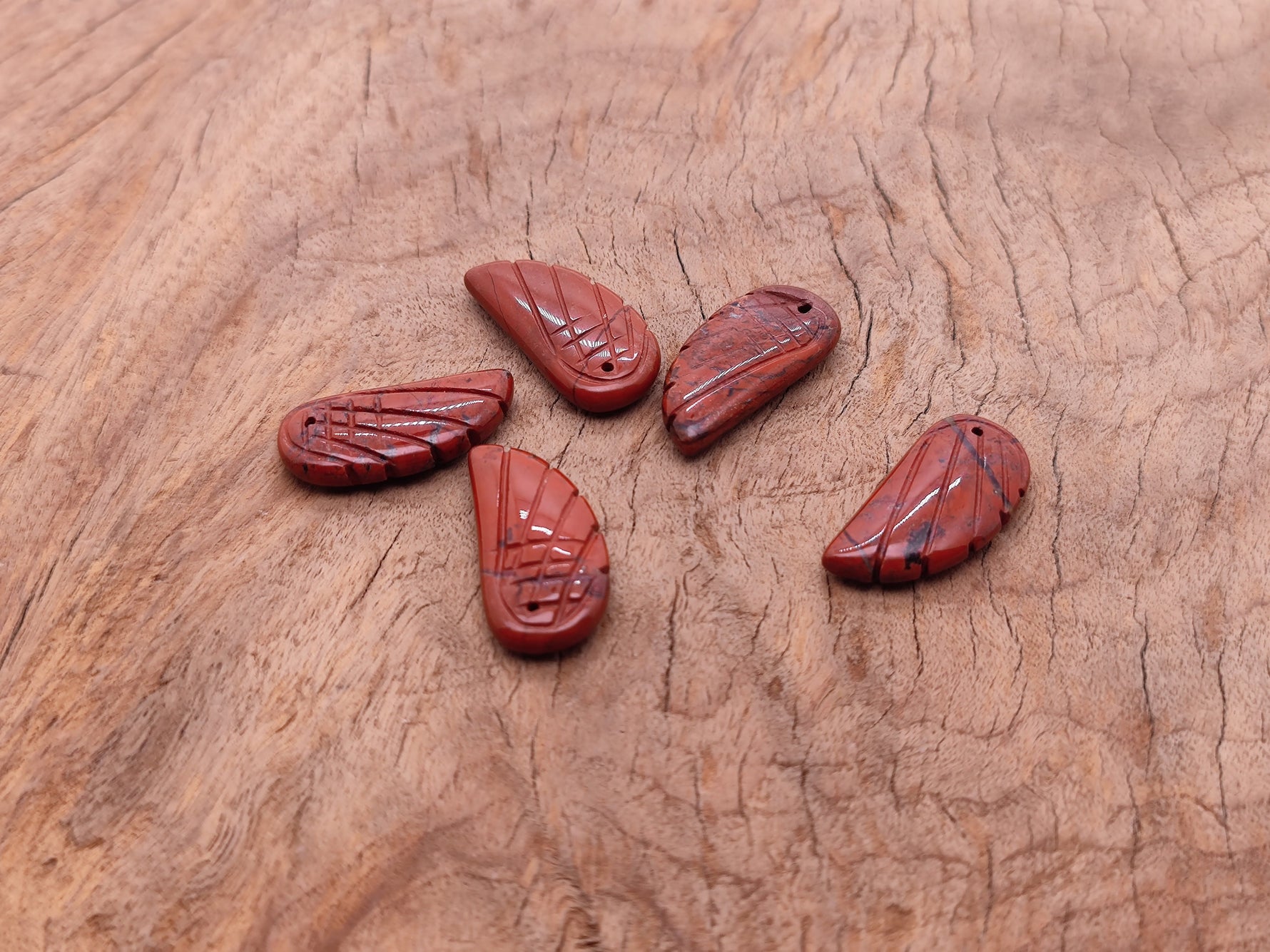 Red Jasper angel wing crystal pendant with hole charm, featuring detailed angel wing design and vibrant red gemstone from GemstoneGO.