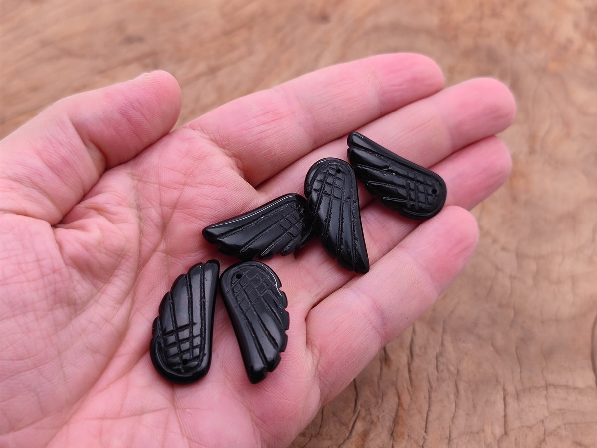 Obsidian angel wing crystal pendant with hole charm, featuring detailed black gemstone wing design on a silver chain.