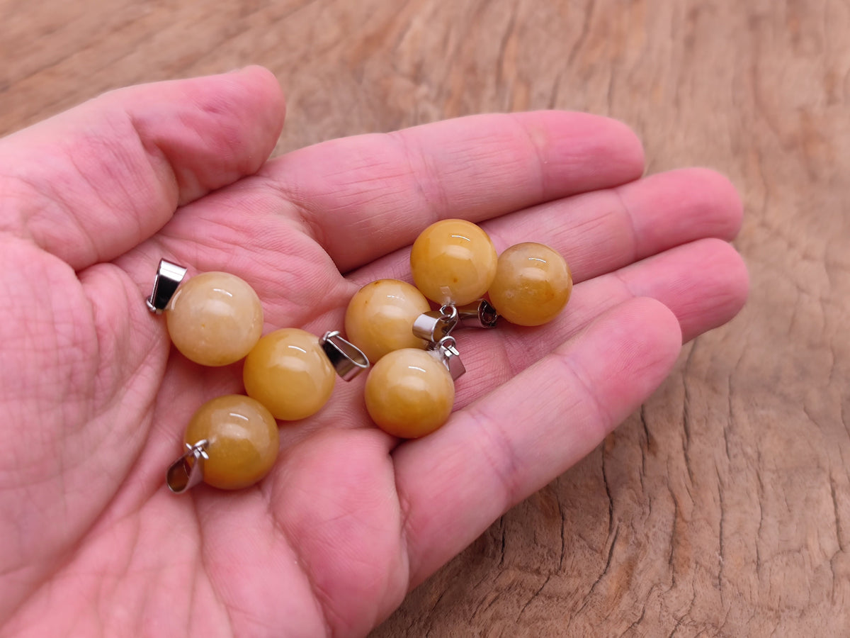 Yellow jade sphere crystal pendant with smooth round shape, ideal for jewelry making by GemstoneGO.